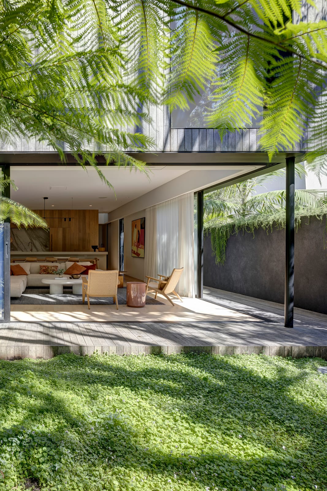 Quarry Box by MCK Architects. Photography by Brett Boardman. Open plan living space opening onto timber deck and lush backyard. 