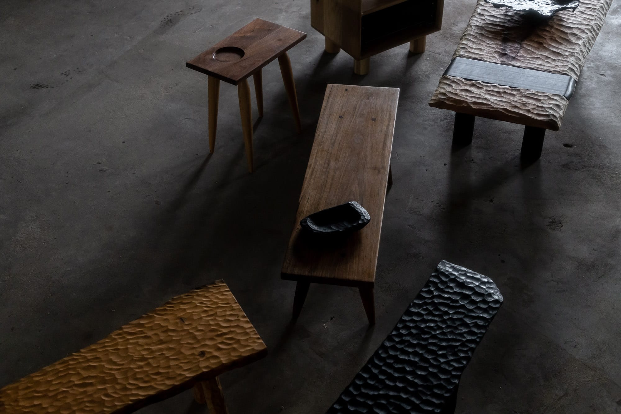 Two Blue Boys. Copyright of Two Blue Boys. Long timber sideboard with eight black table legs. Carved texture over benchtop and legs. 