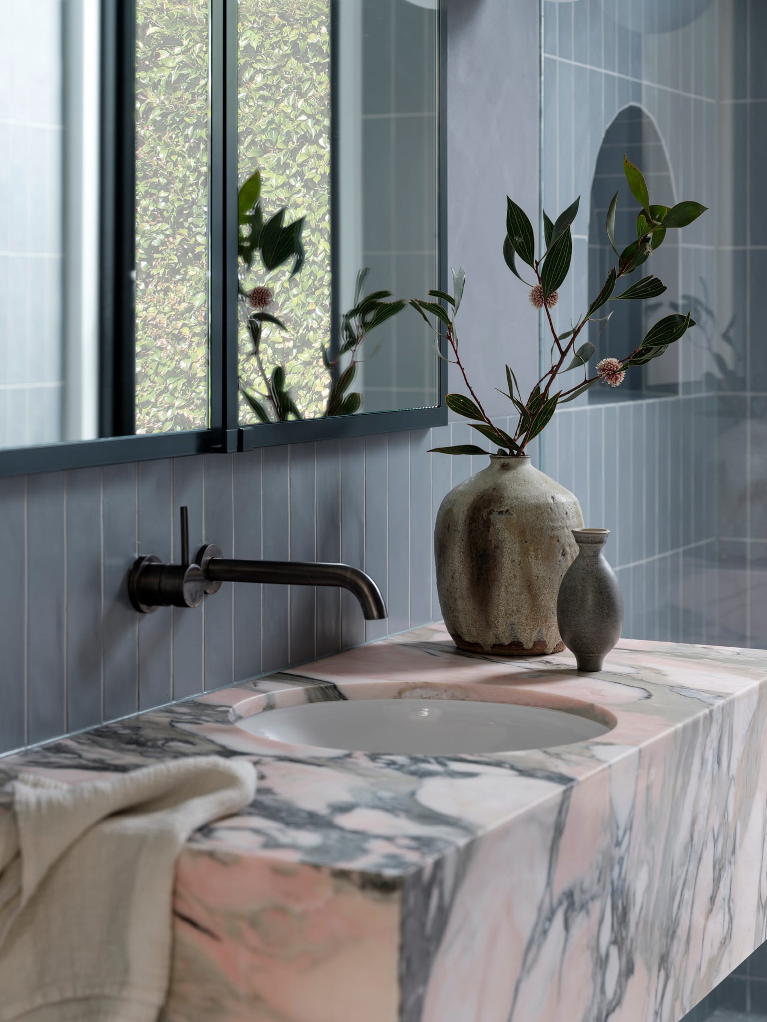 Bellevue House by Carla Middleton Architects. Photography by Tom Ferguson. Rose and grey marble bathroom benchtop with inset round sink and burnished brass sink. Grey subway tiles on wall. 