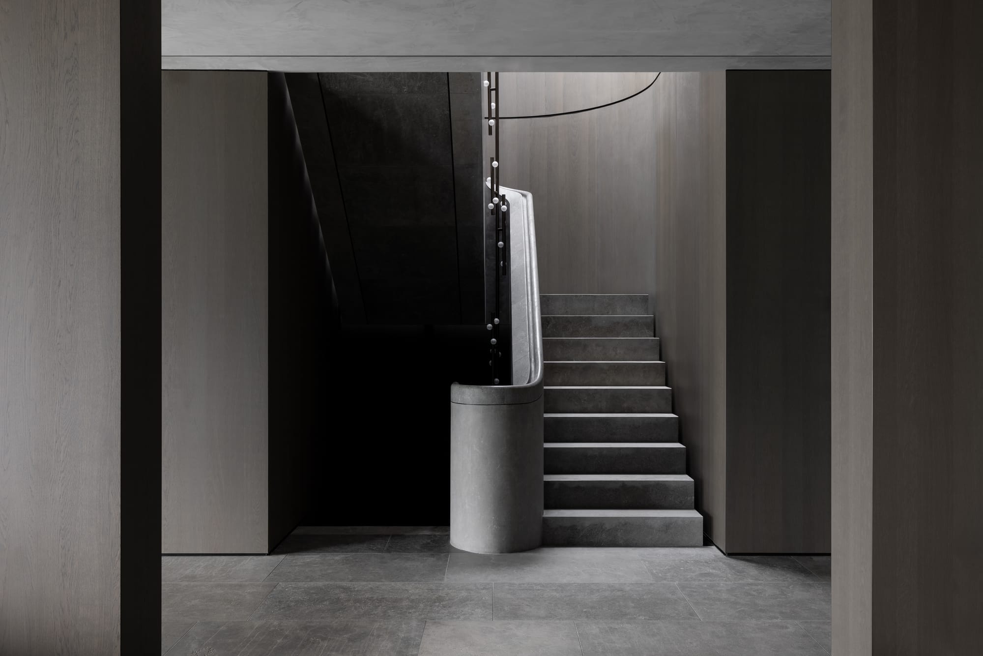 Cliff House by Finnis Architects. Photography by Timothy Kaye. Stone curving staircase with timber veneer walls. Lighting following stairs.