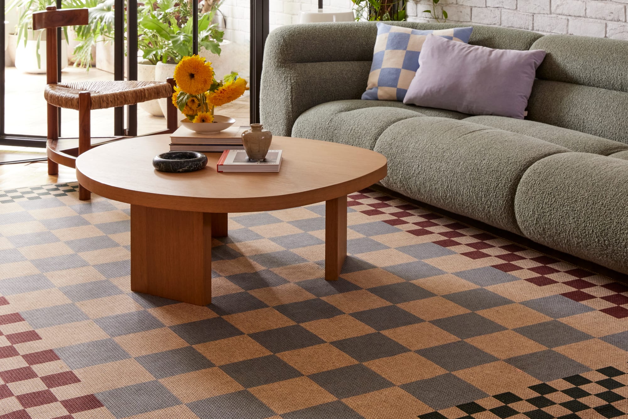 Checkered Brown New Jute Rug by Double. Photographer: Jacqui Turk. Checkered multicoloured rug under timber coffee table and green couch. 