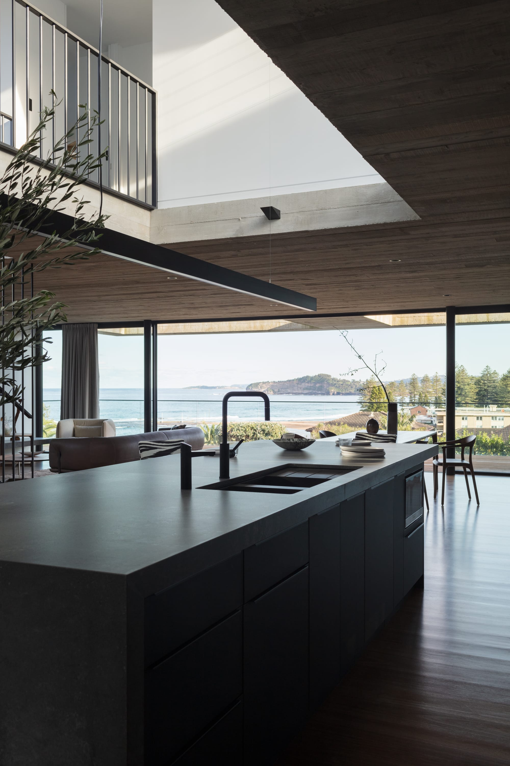 An interior shot of the kitchen showing the island bench and the ocean views in the background