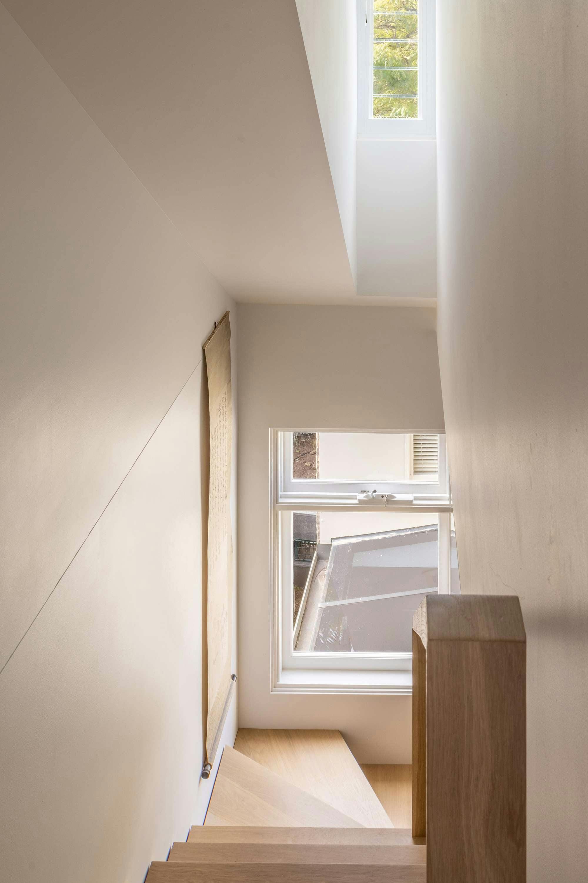 An interior shot looking down the new timber stair and a window looking out to the rear