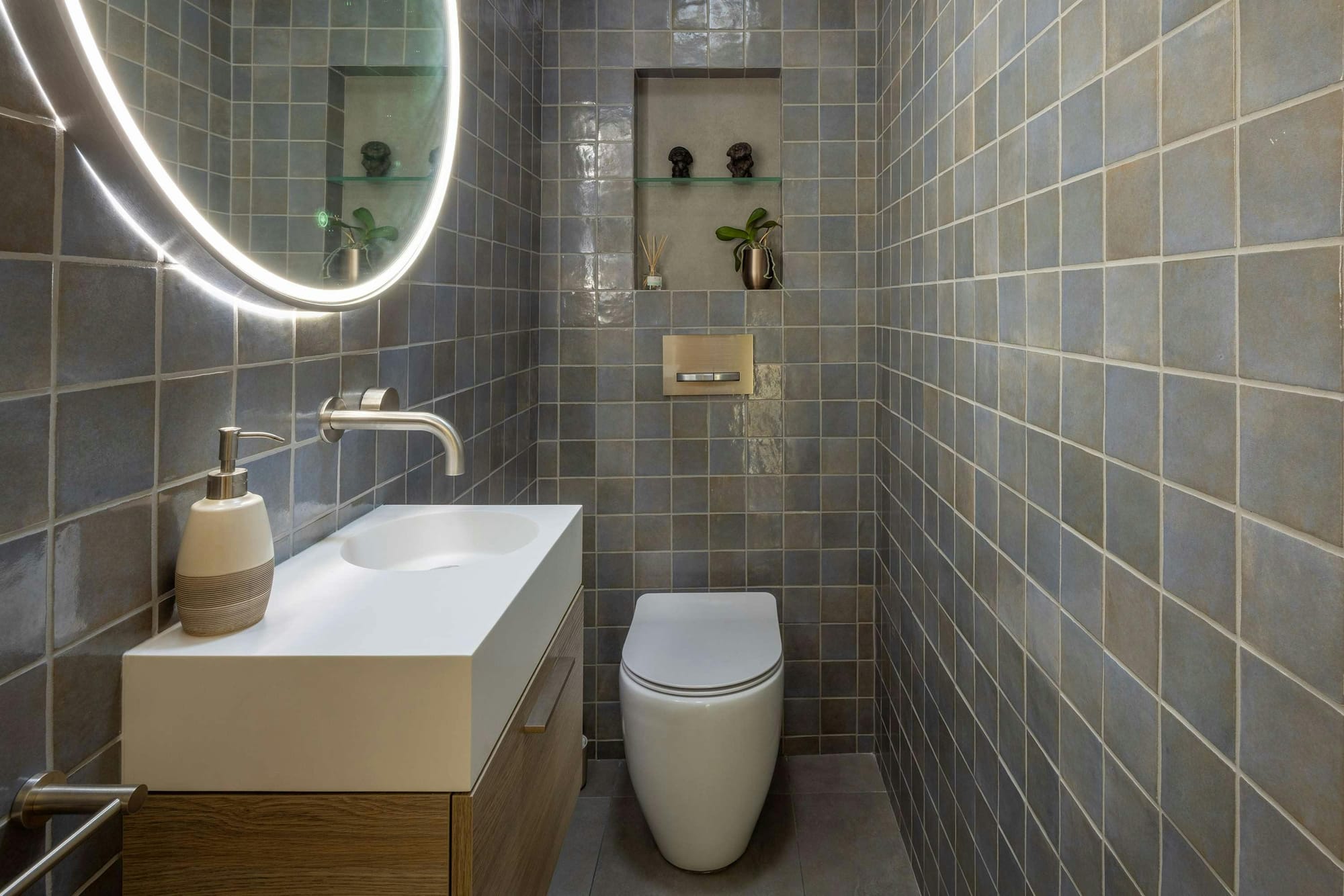 An interior shot of the newly renovated bathroom with grey green tiles