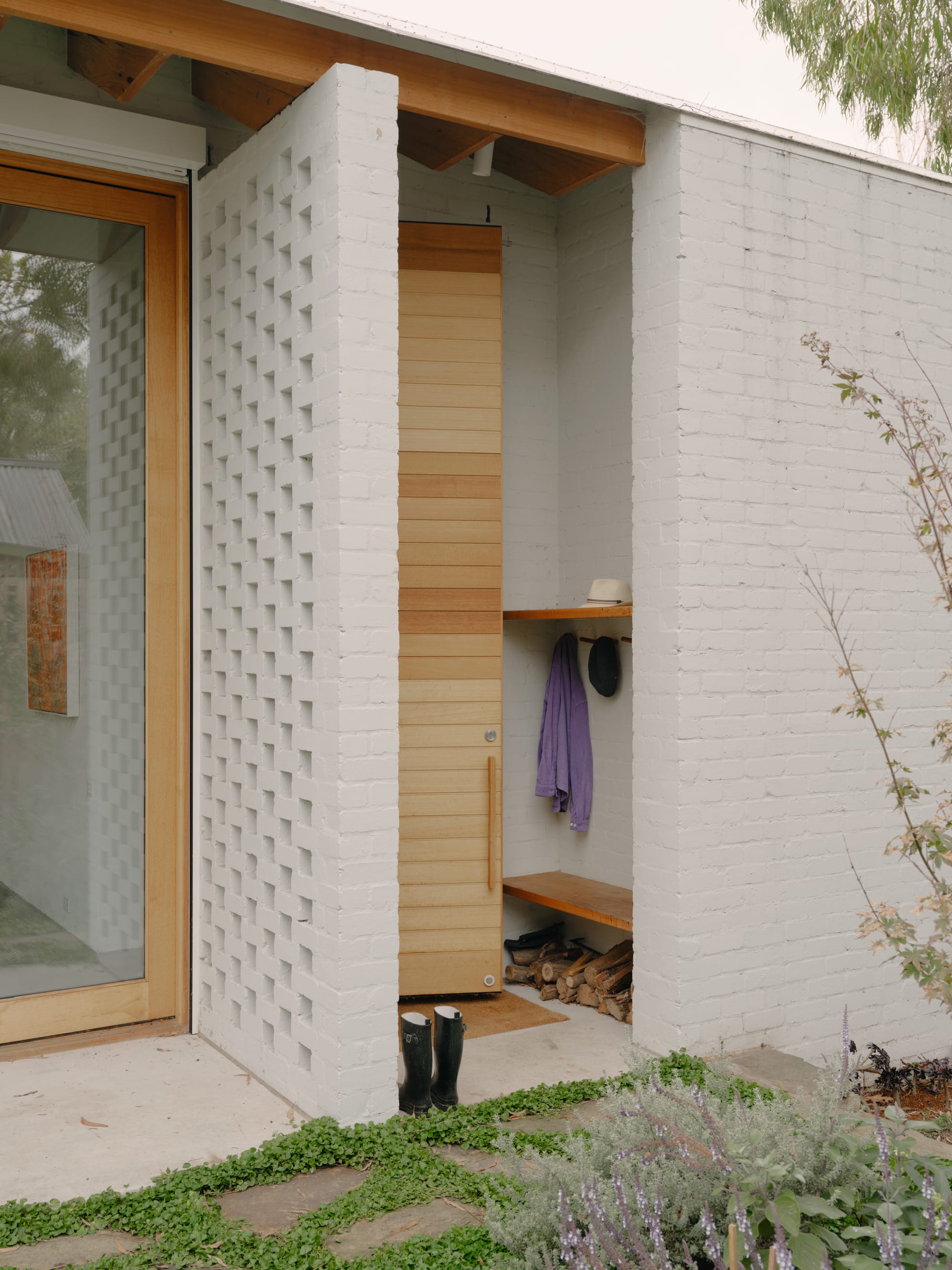 Corymbia by Karen Abernethy Architects. Photography by Tom Ross. Exterior white brick home with breezeblock partition wall and timber framed glass doors. 