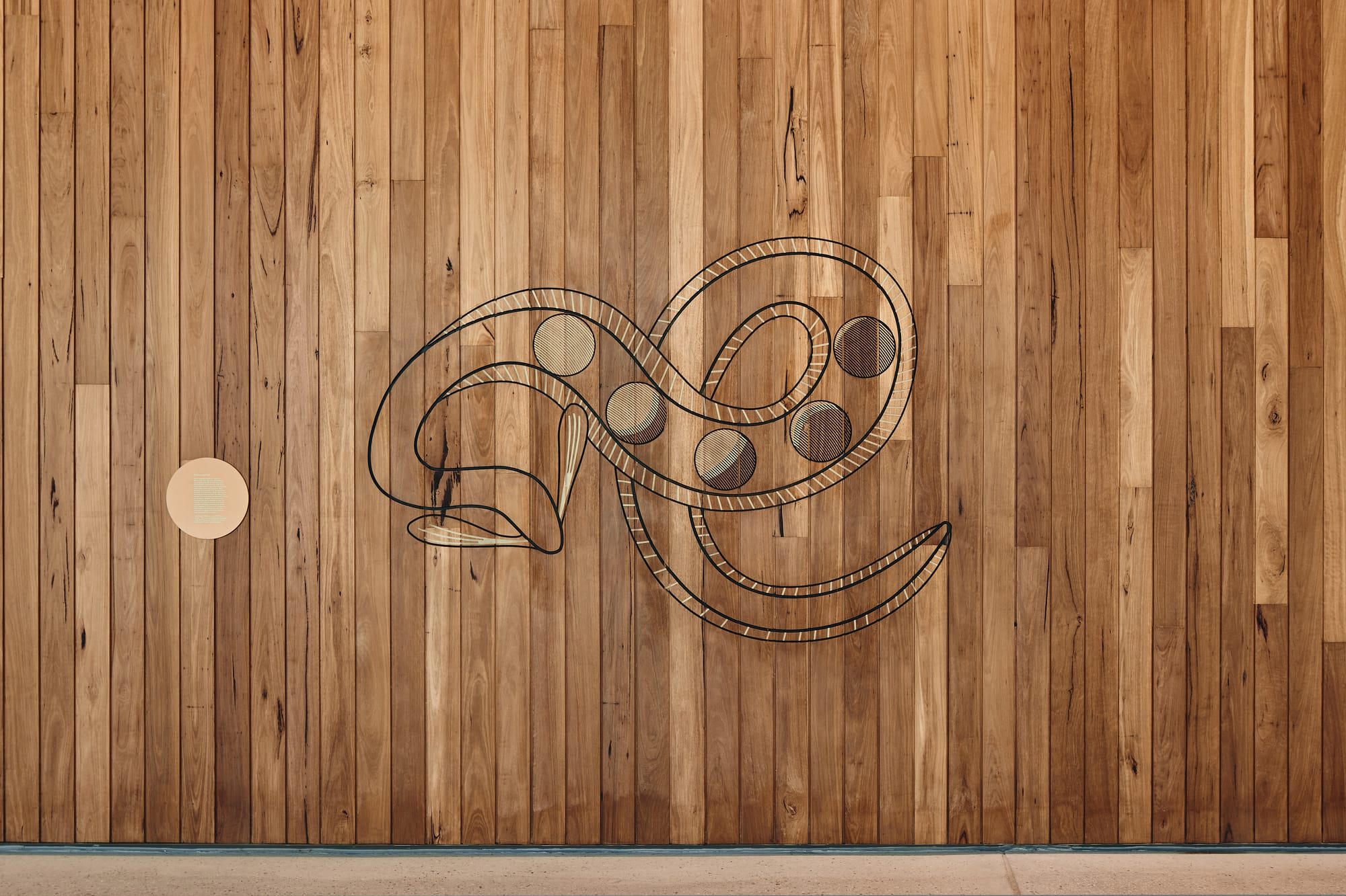 Parramatta Aquatic Centre by Mortlock Timbers. Photography by Peter Bennetts. Snack design burned into timber clad walls. 