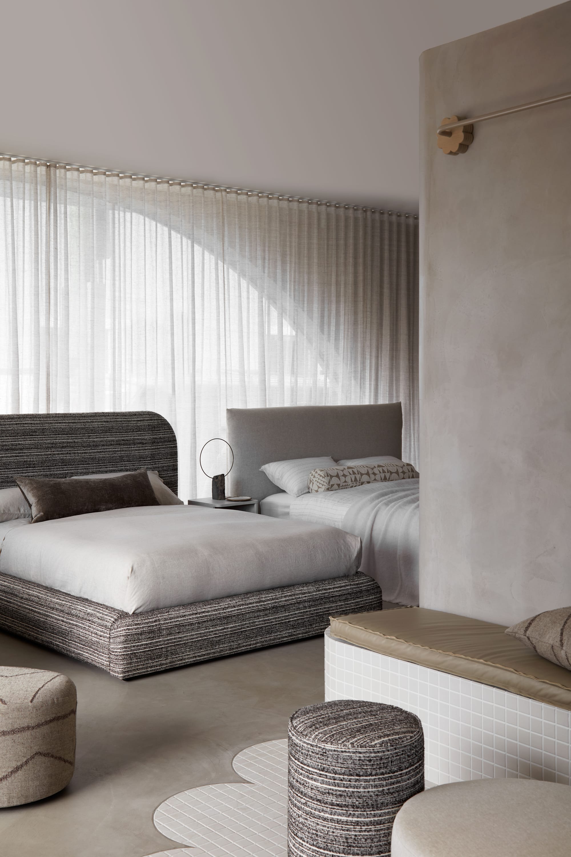 Zenn Showroom. Photography by Elisa Watson. Selection of upholstered beds with neutral linen. Tiled bench seat in foreground.