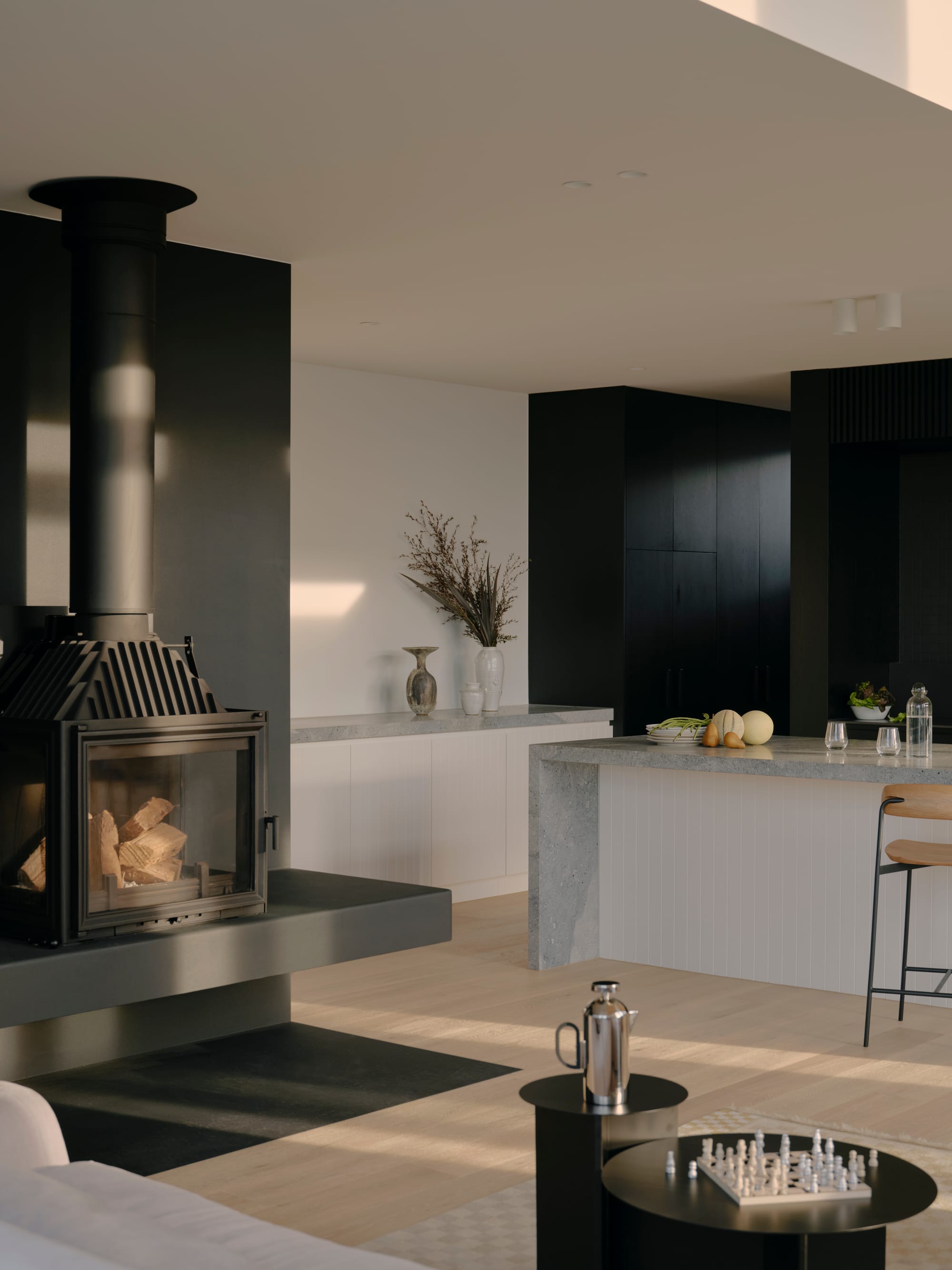 Courtside House by Tom Robertson Architects showing the living room space with a feature fireplace