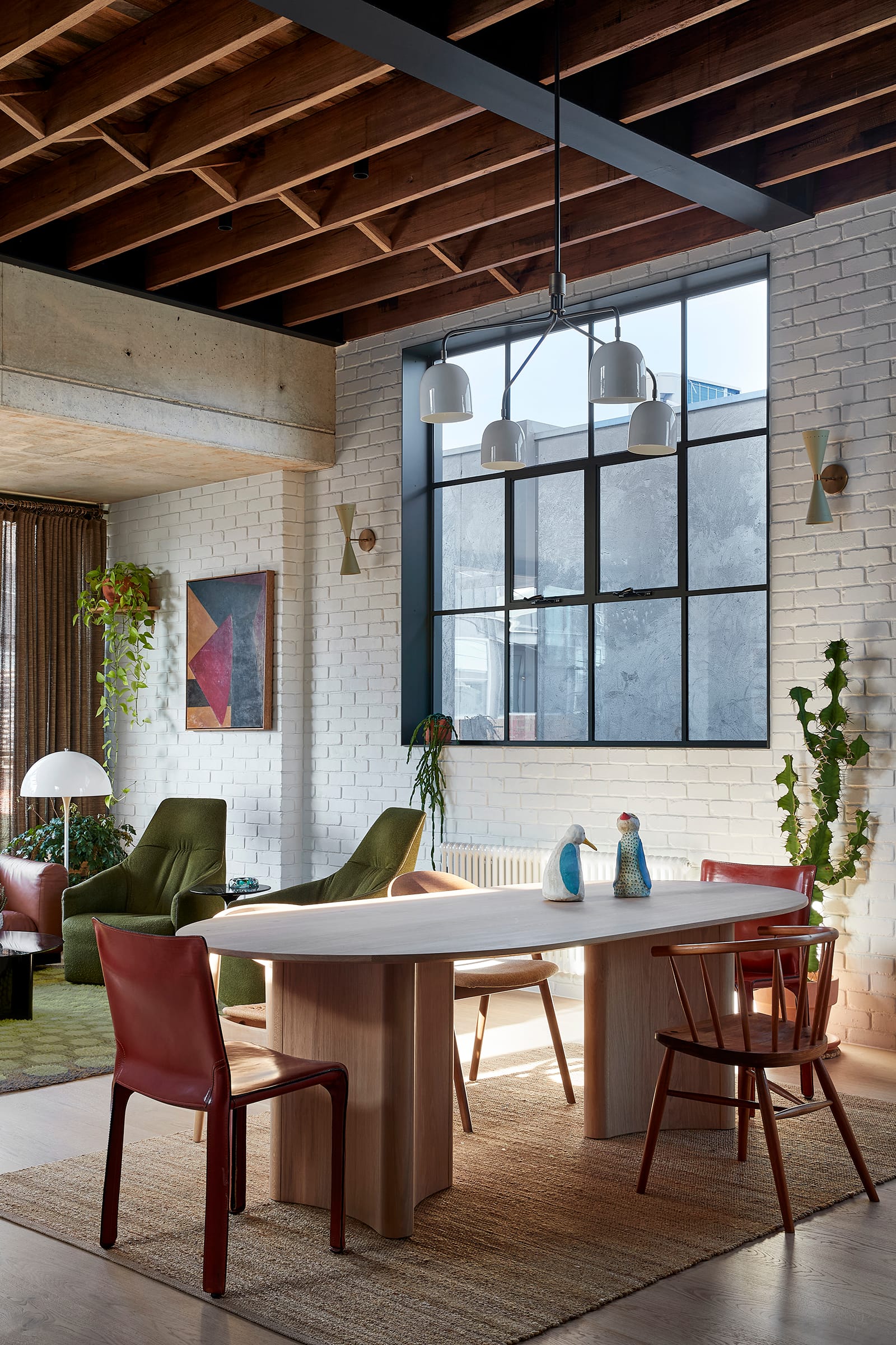Fabrica by mcmahon and nerlich. Photography by Shannon McGrath. Timber dining table with eclectic chairs. White brick walls, jute rug. 