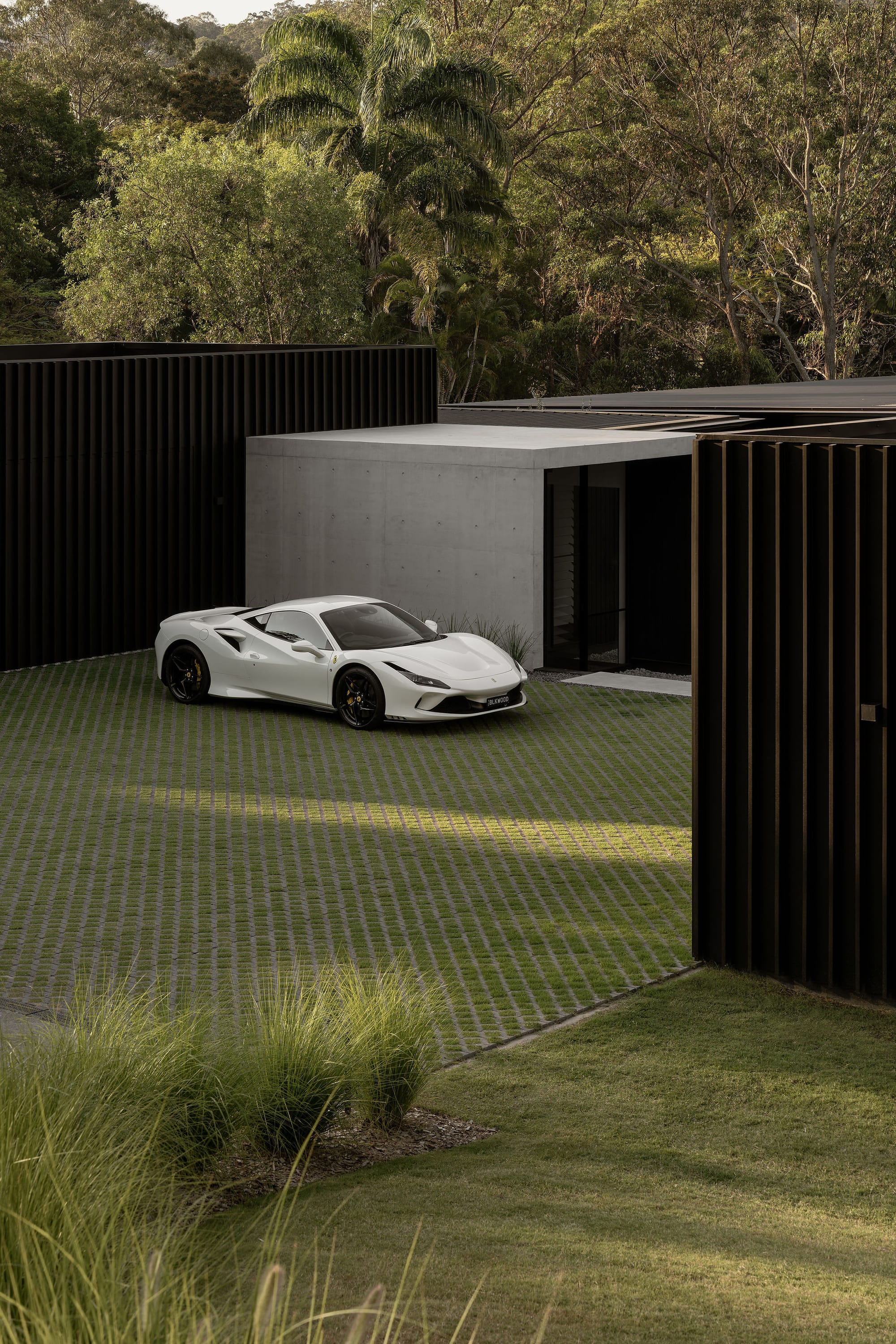 Blackwood by Sarah Waller Architecture. Photography by Alyne Media. Enclosed glass walkway joining two pavilions. Crushed stone courtyard and outdoor living space. 