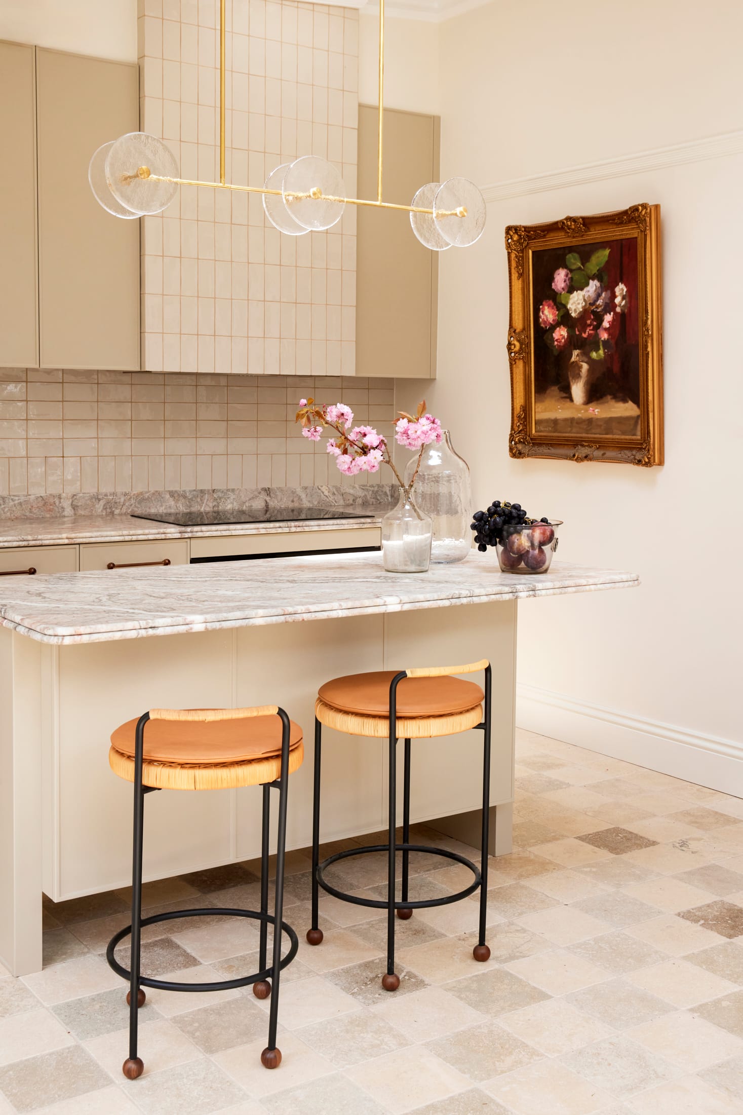 Drummoyne House by studio BARBARA. Photography by Jacqui Turk. Kitchen with checkered travertine floors and white cabinetry. Marble benchtops. Tan leather and black metal stools.