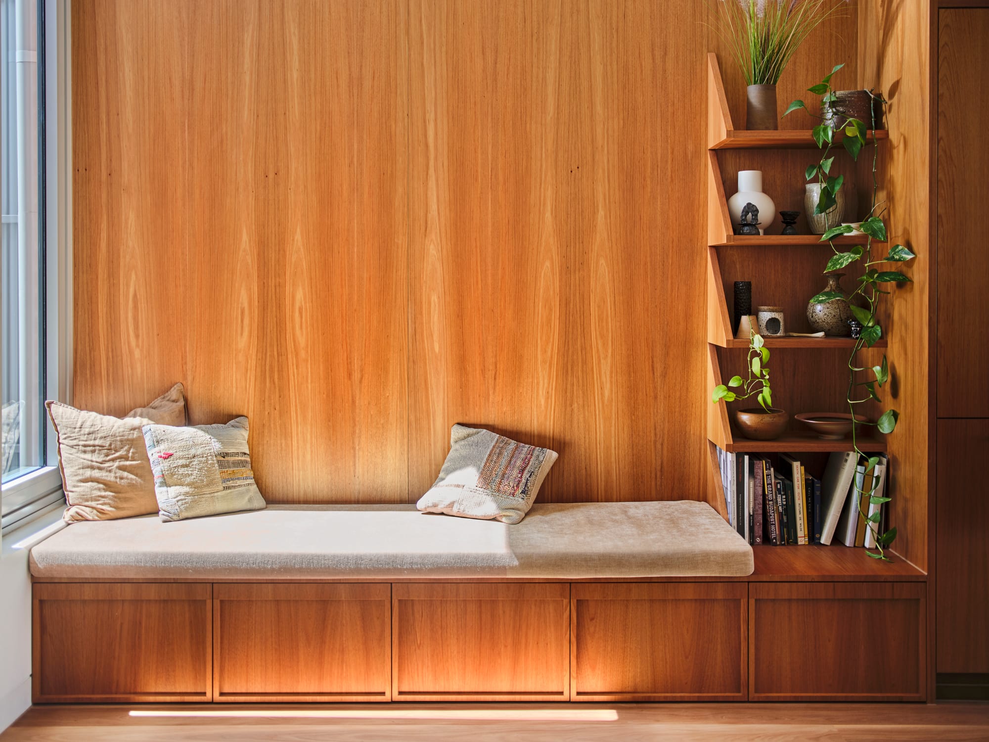 House Northroy by True Story. Photography by Dean Bradley. Reading nook with timber floors, walls and integrated bench seat and floating shelves.