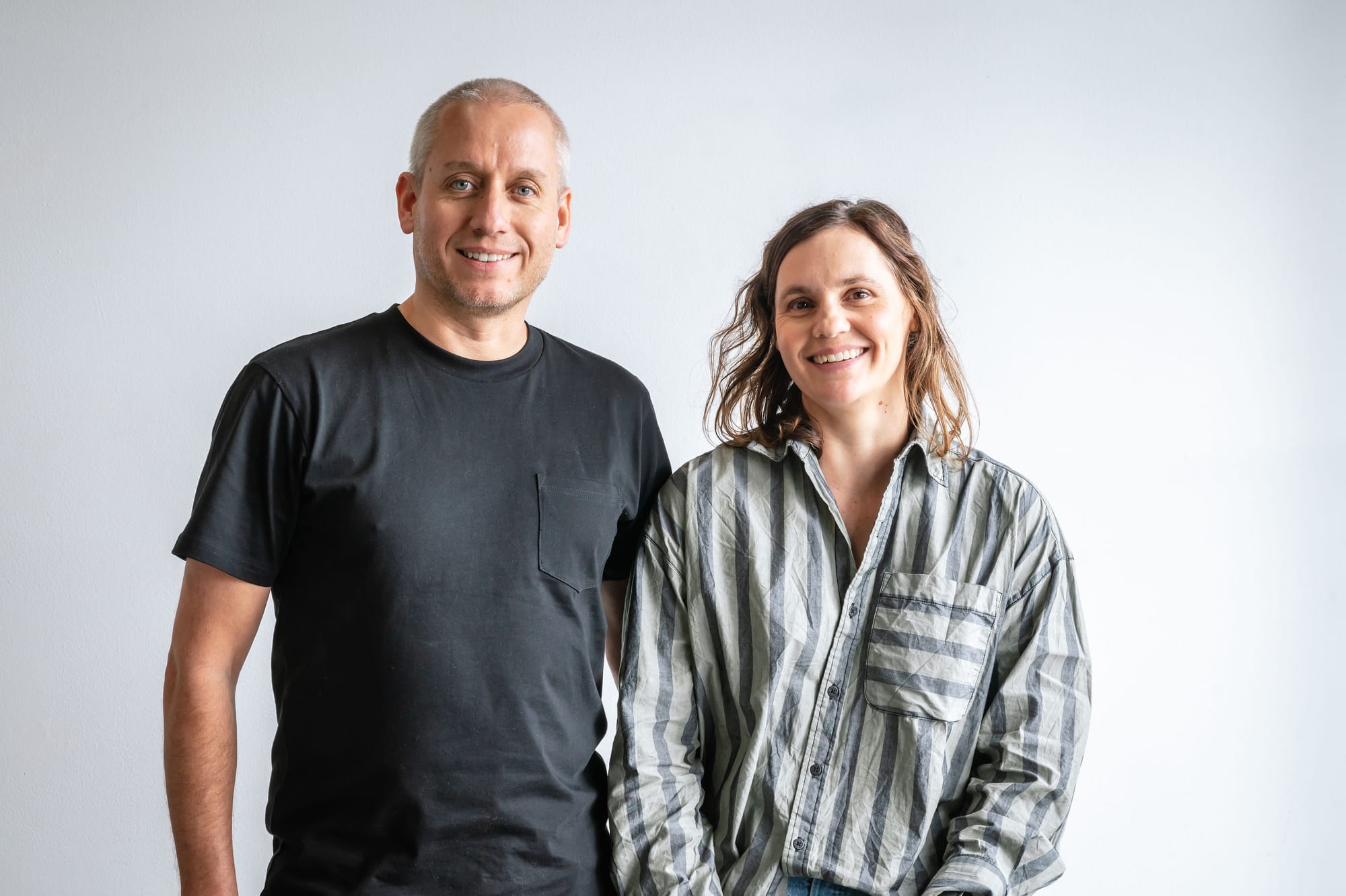 Simon and Rebecca of Peninsula House Numbers. Copyright of Peninsula House Numbers. Man in black t-shirt and woman in striped shirt smiling.