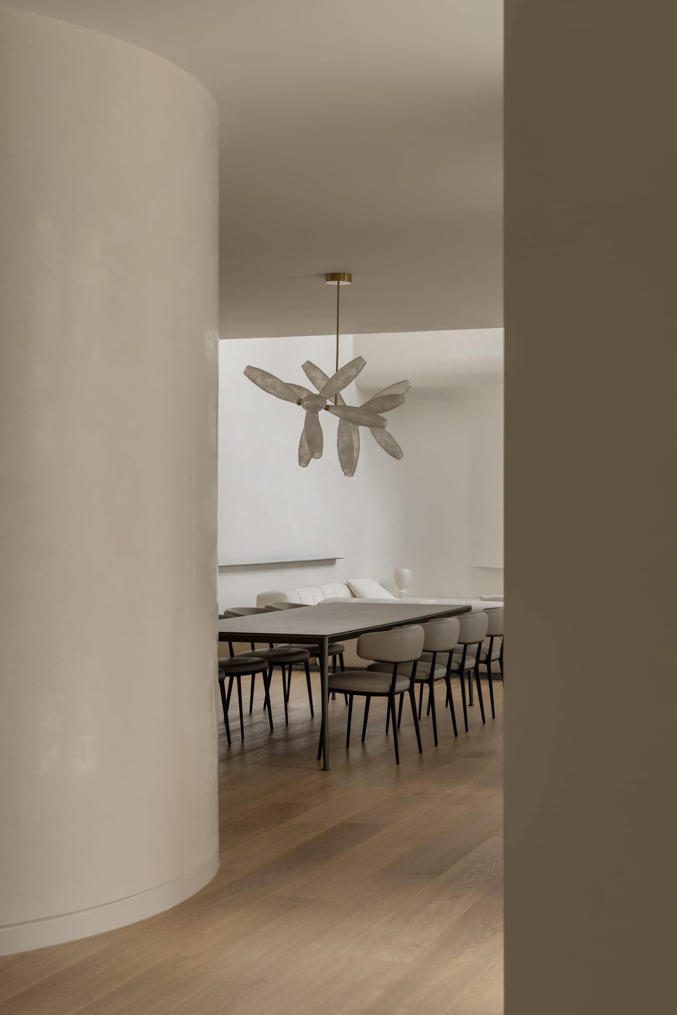 An interior shot from the hallway showing the cream rendered walls and a view into the dining space with a feature pendant light above
