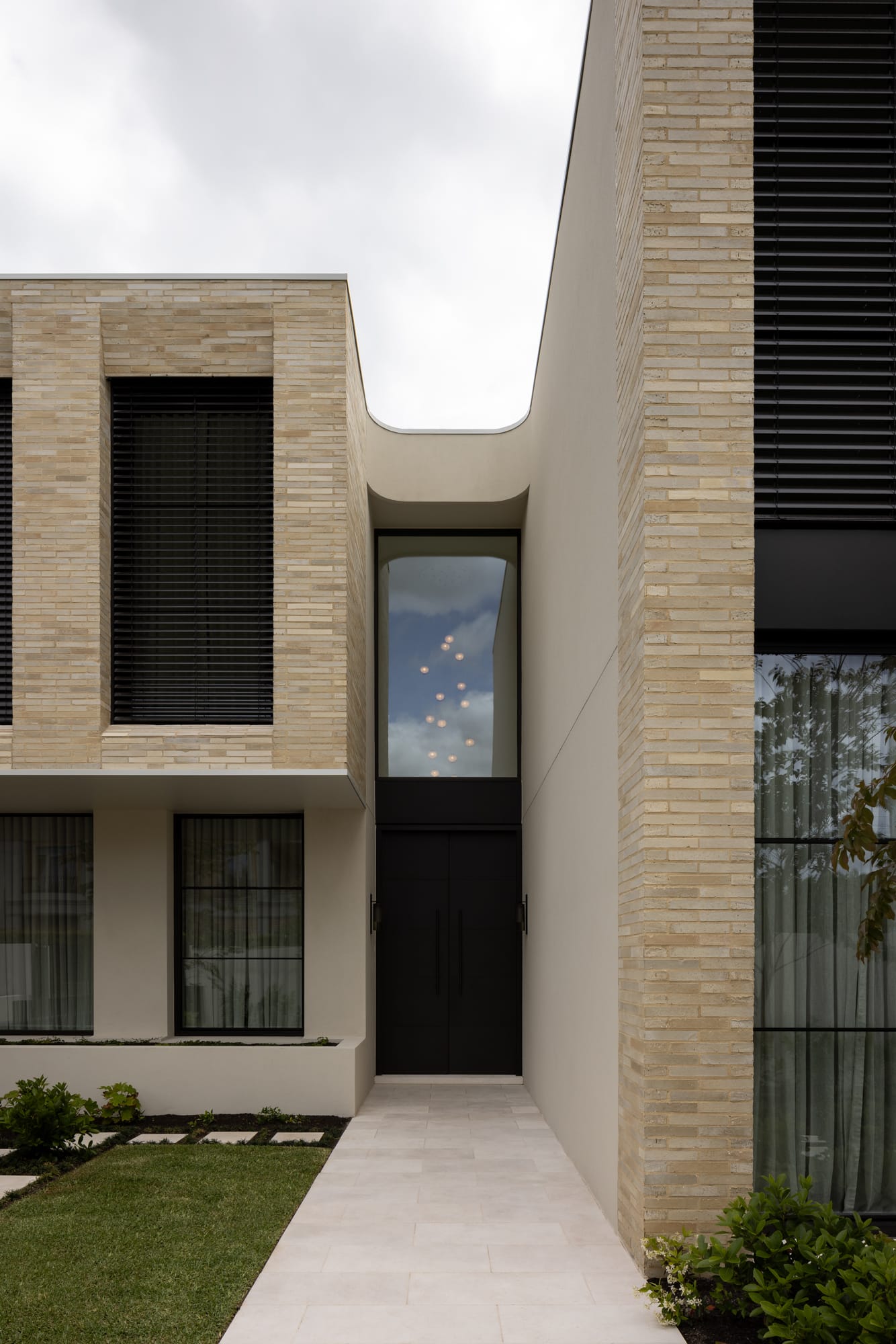 An exterior shot of the front facade of the brick home showing the entry door and a large window above
