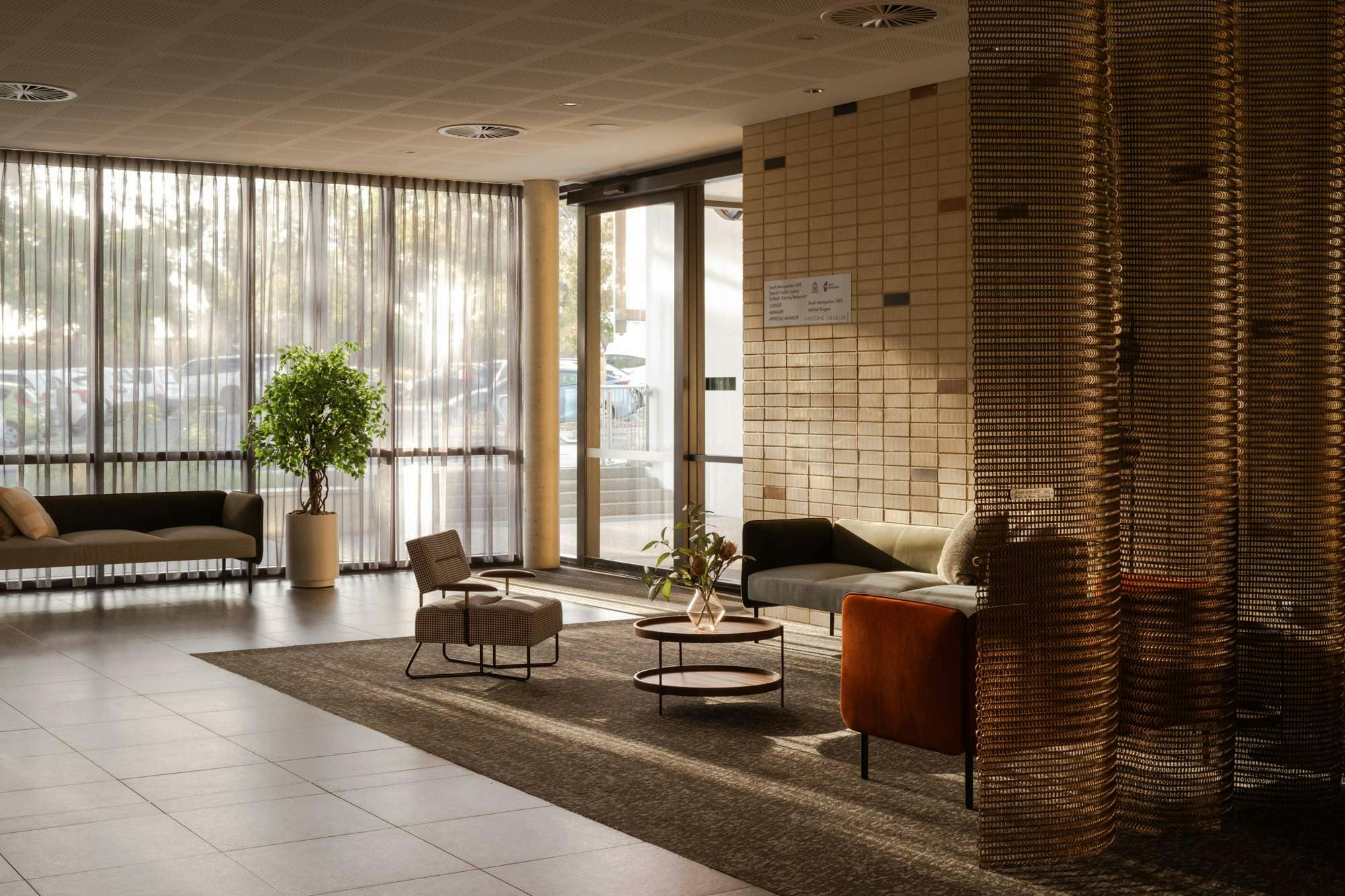 South Metropolitan TAFE Hospitality Facility by Hunt Architects. Lobby entrance with seating facilities and metal optic curtains.