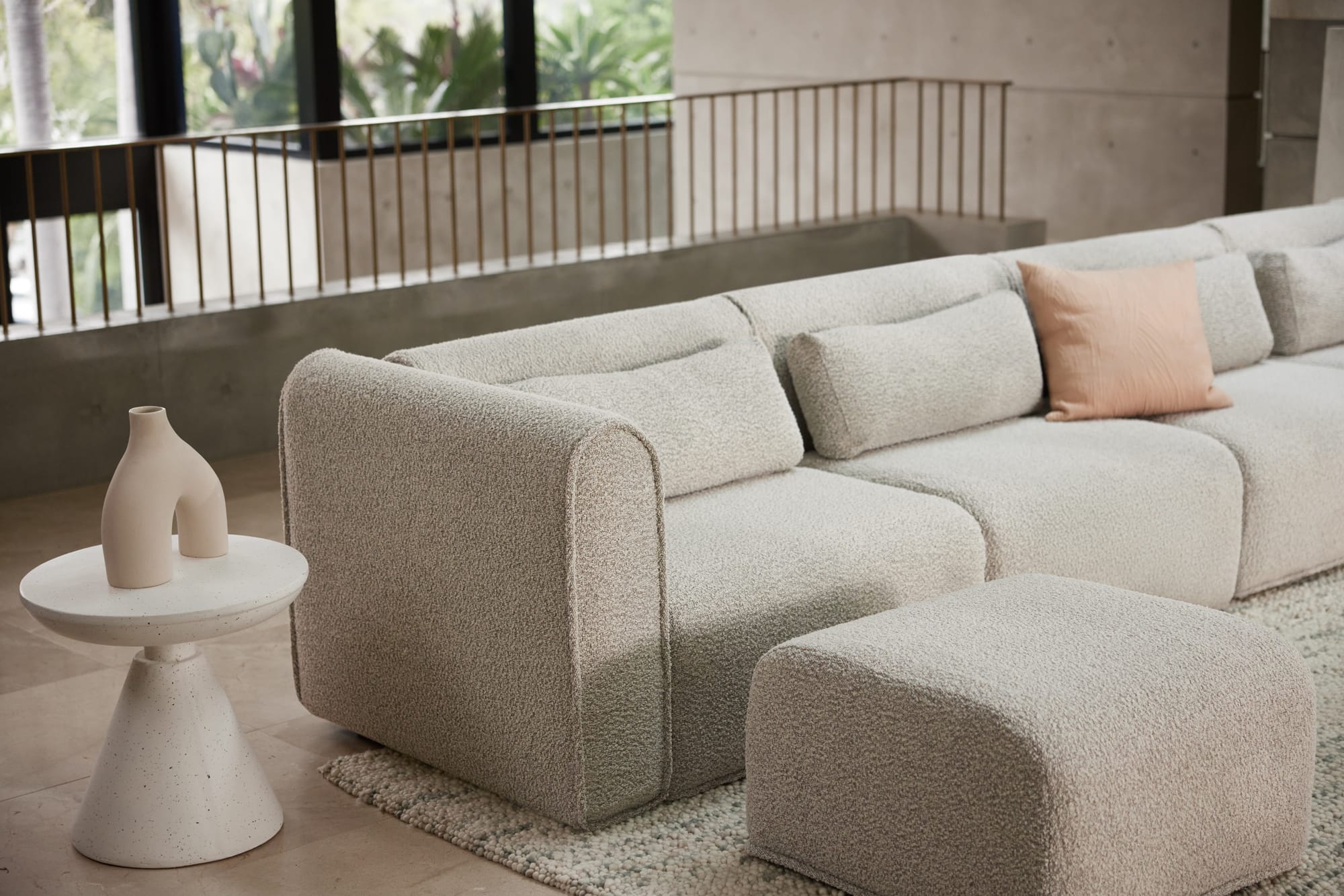 Bangalow Modular Sofa in Limestone. Light stone grey boule modular armchair in concrete and beige living space. 