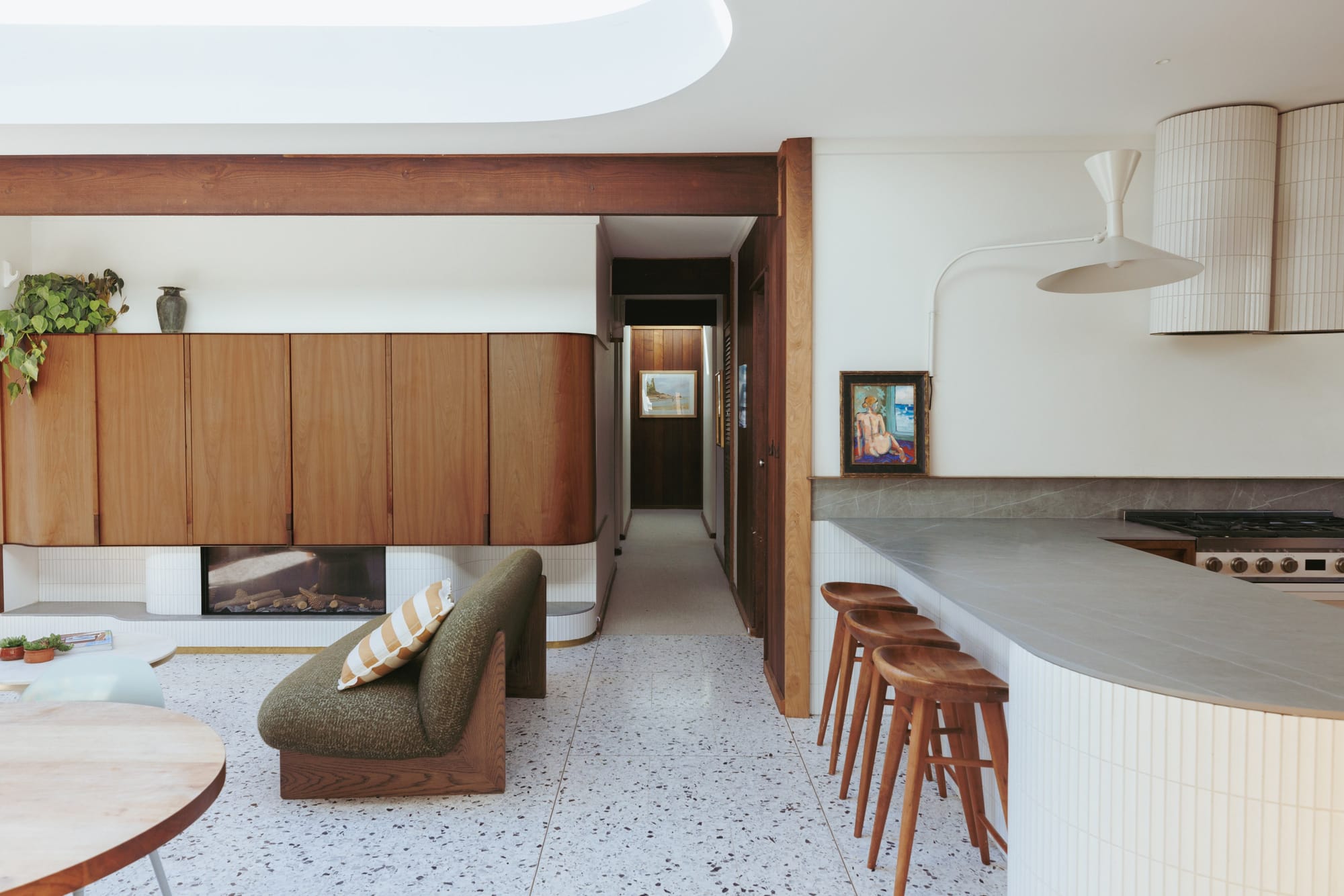 Haka House by Taouk Architects. Photography by Emily Bartlett. Living space with herringbone flooring, exposed brick accents, sheer curtains and leafy plants.