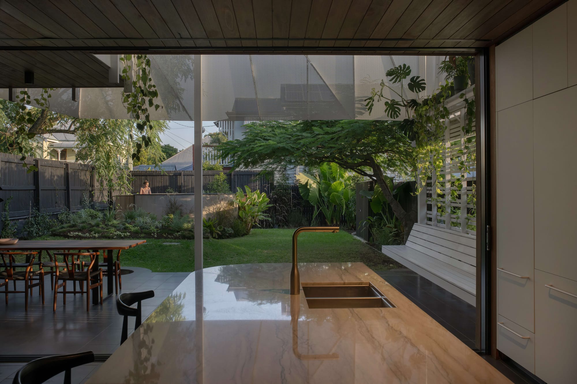 Glenmore Road House by BY SOMA. Photograph by Daniel Cook. Curved abstract chaise chair next to marble fireplace.
