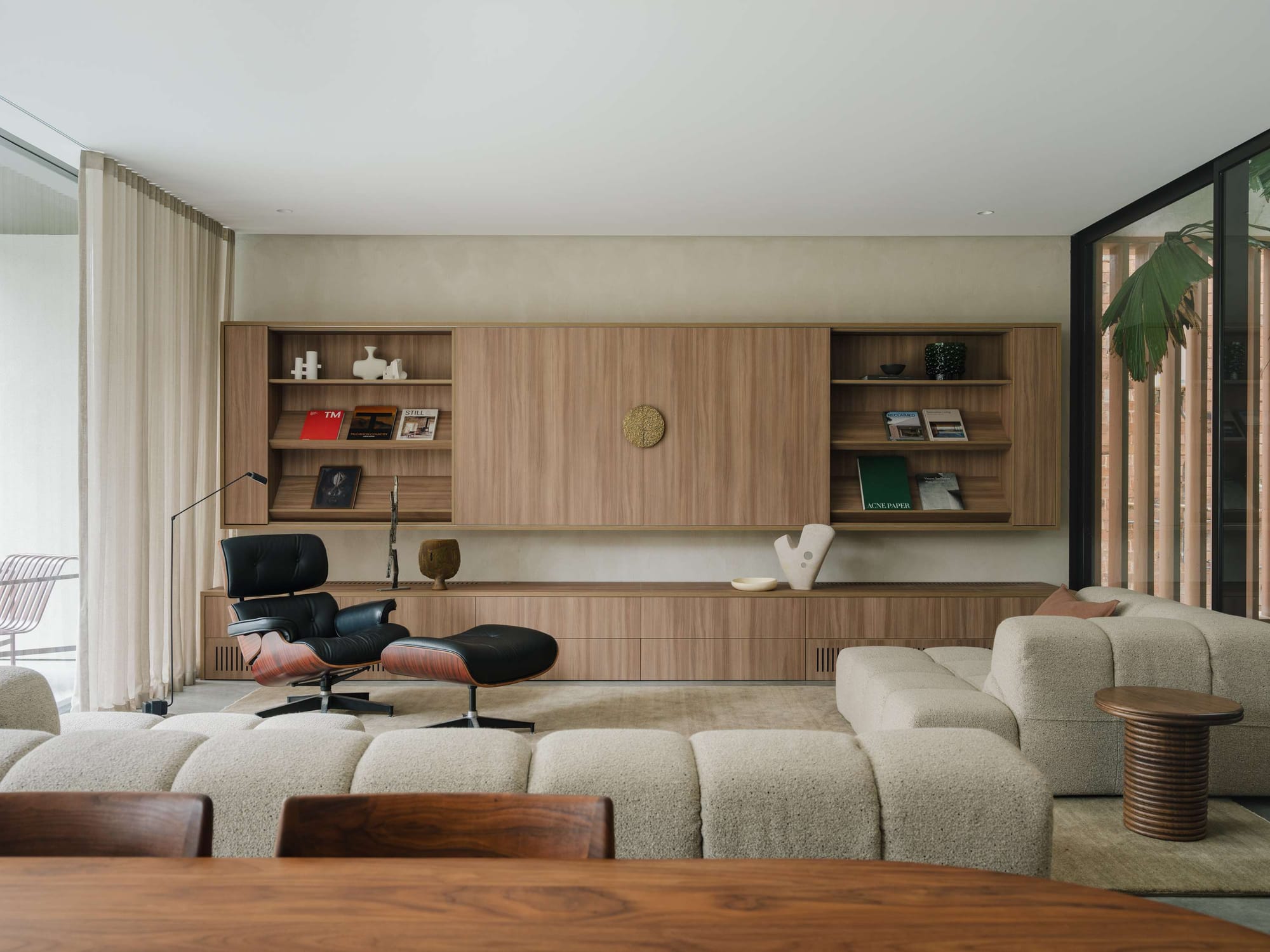 Petersham House by Cateaux Architects. Photography by Clinton Weaver. Living space with tufted boucle modular lounge, timber cabinetry, limewashed walls, and mid-century modern furnishings. 