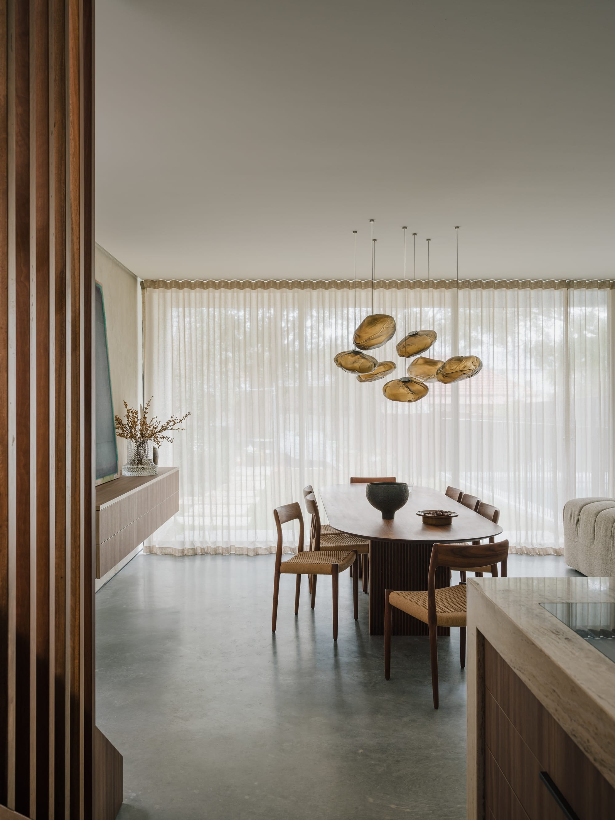 An interior shot of Petersham House showing the open ding space with a designer timber dining set and glass pendant light above.