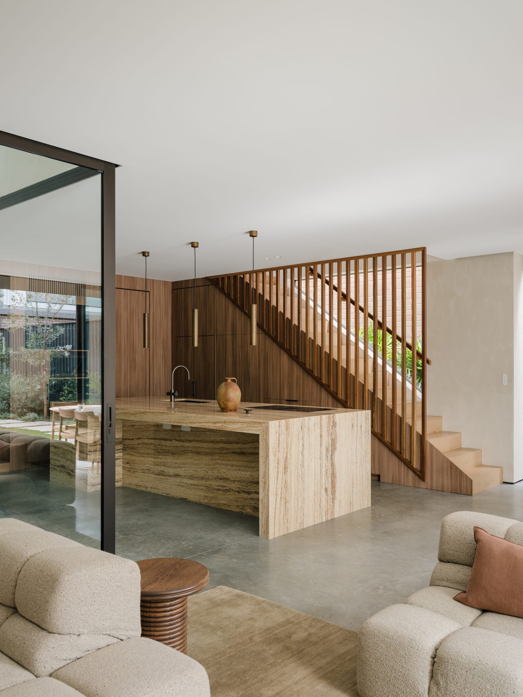 An interior shot of Petersham House showing the modern kitchen with a timber staircase behind.