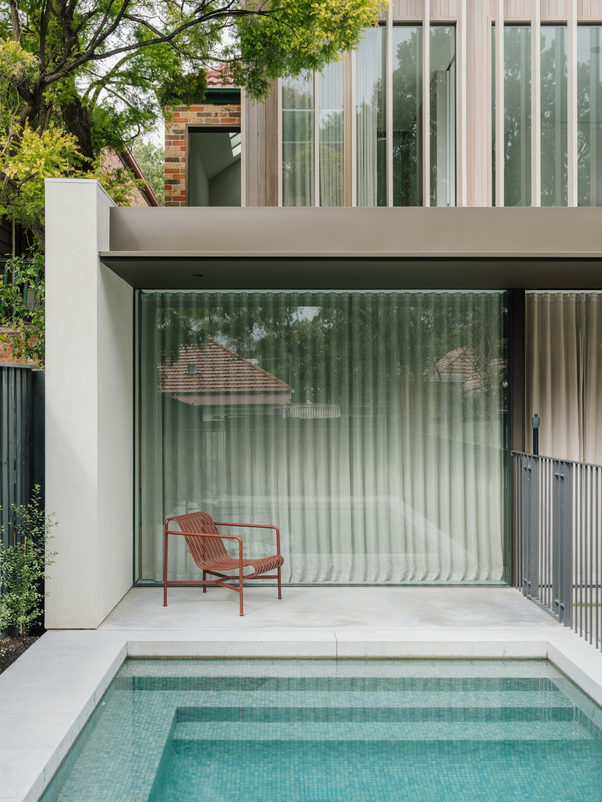 Petersham House by Cateaux Architects with CHROFI. Photography by Clinton Weaver. Double storey contemporary rear facade with tiled pool in foreground