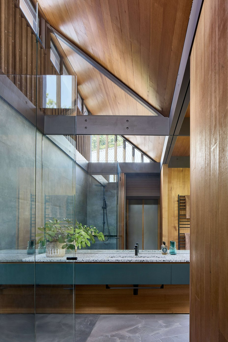 Eaglemont House by BENT Architecture. Photography by Tatjana Plitt. Wet room bathroom with stone flooring, moss green counter, pitched ceilings and glass shower screens.