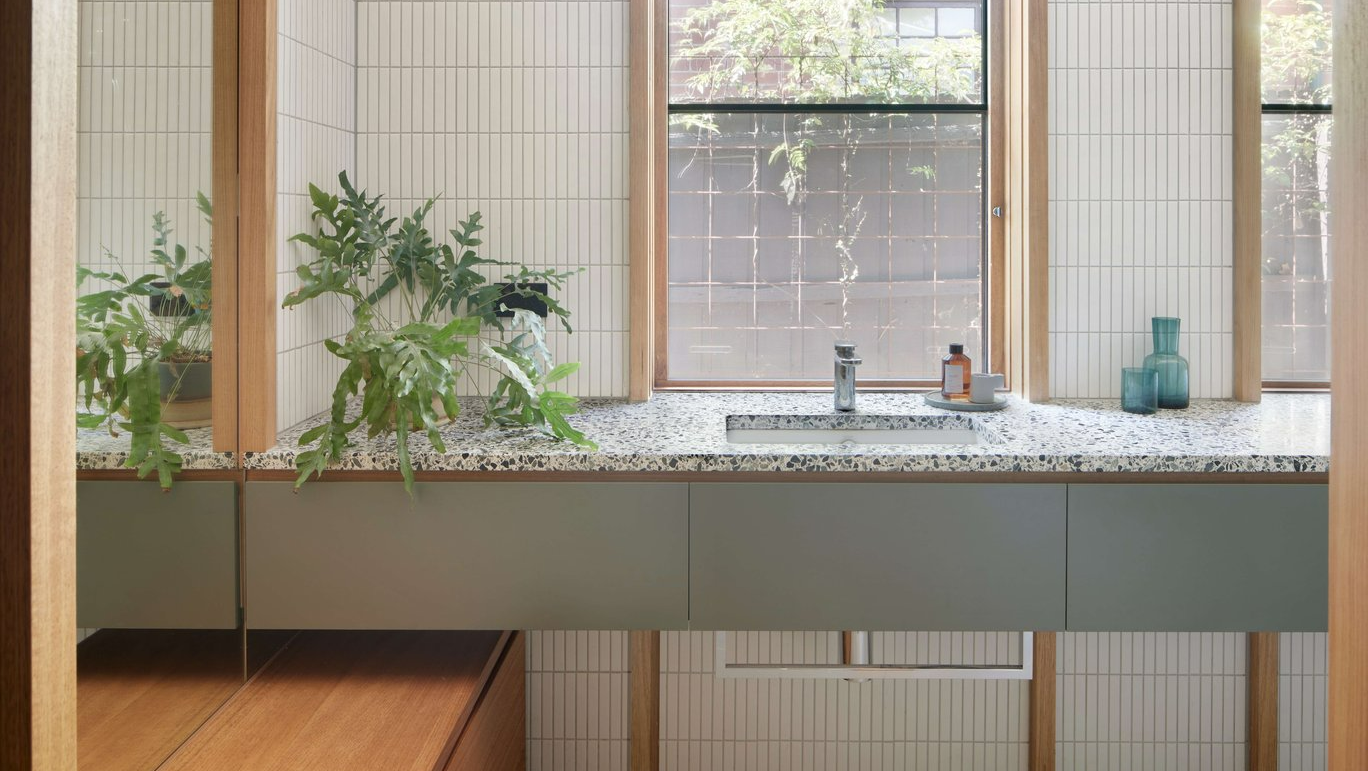 Eaglemont House by BENT Architecture. Photography by Tatjana Plitt. Wet room bathroom with stone flooring, moss green counter, pitched ceilings and glass shower screens.