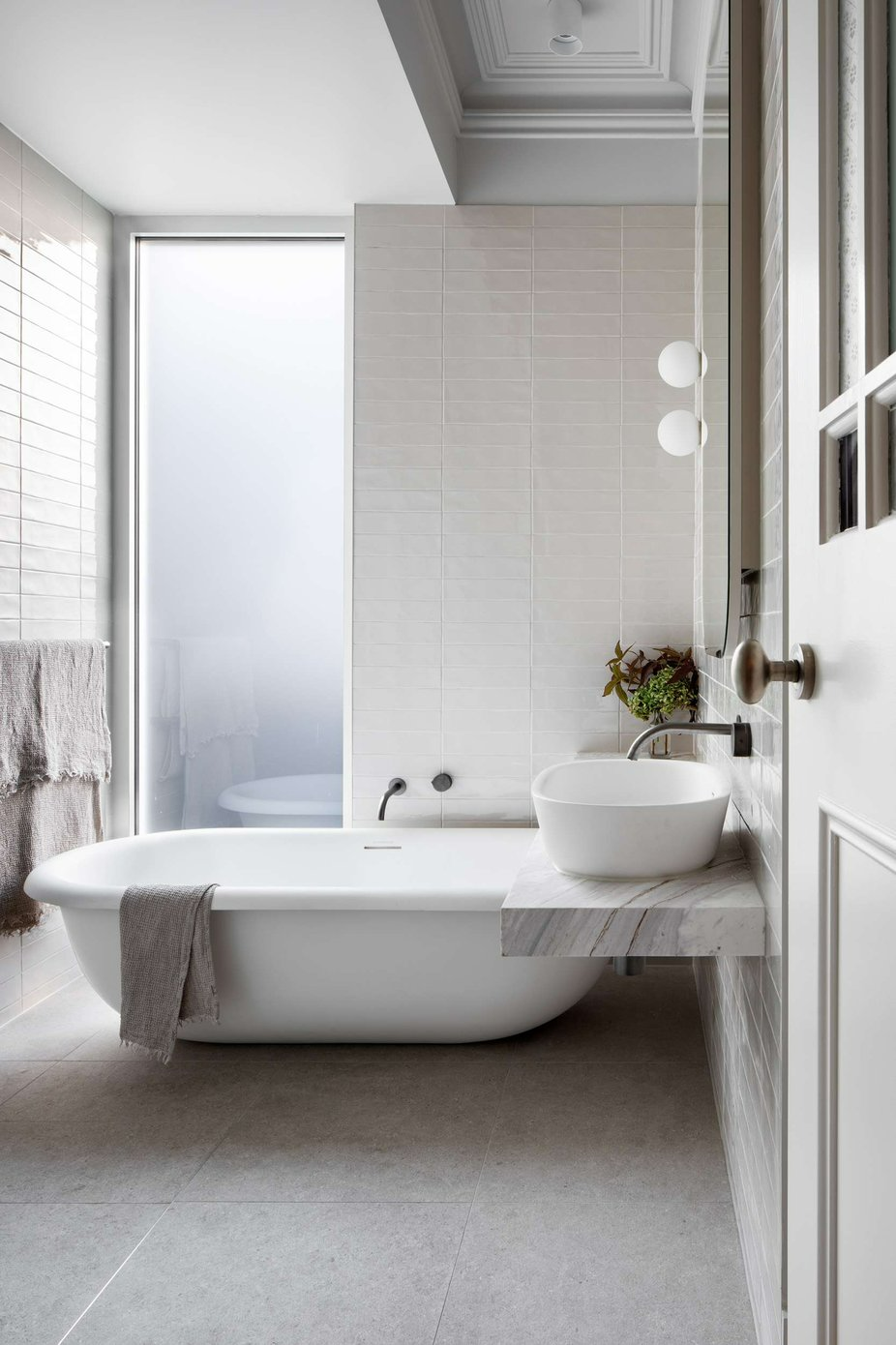 South Terrace Renovation by Chan Architecture. Photography by Tatjana Plitt. Heritage-inspired bathroom with freestanding bathtub, floating stone bench and skylight.
