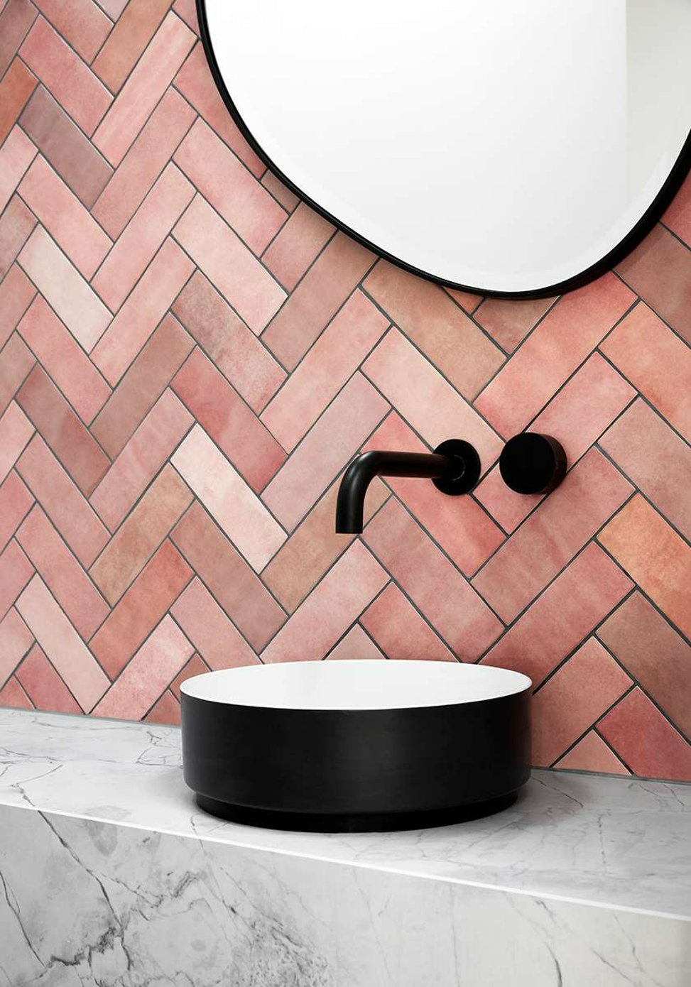 Long Street by Keen Architecture. Photography by Tess Kelly. Close up of black round sink on marble countertop, with black wall mounted tap on terracotta wall tiles in chevron print.