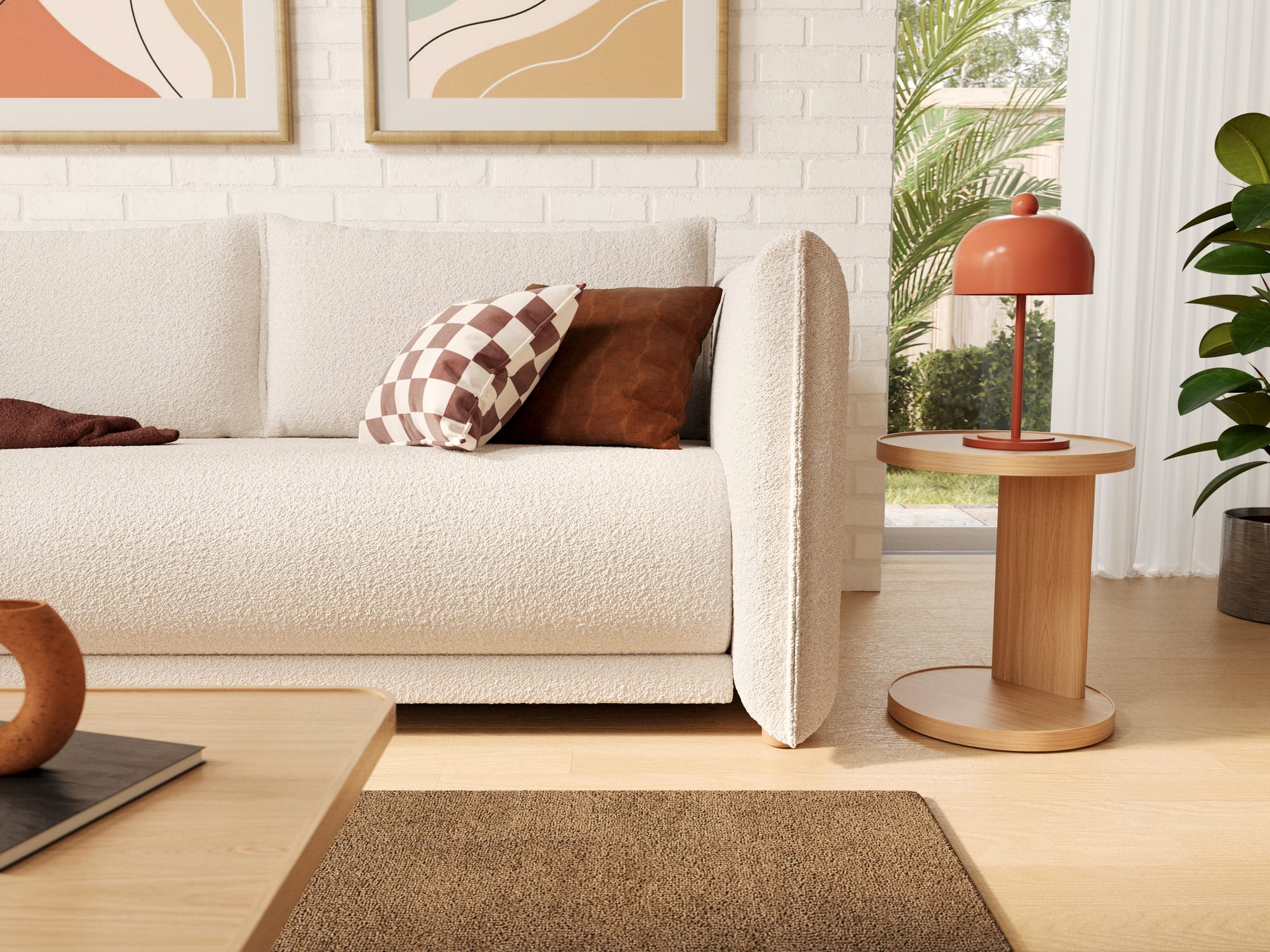 Byron Sofa Bed in Ocean Salt by Koala. Close up of white boucle couch with brown throw cushions, next to a timber coffee table and in front of a white brick wall. 