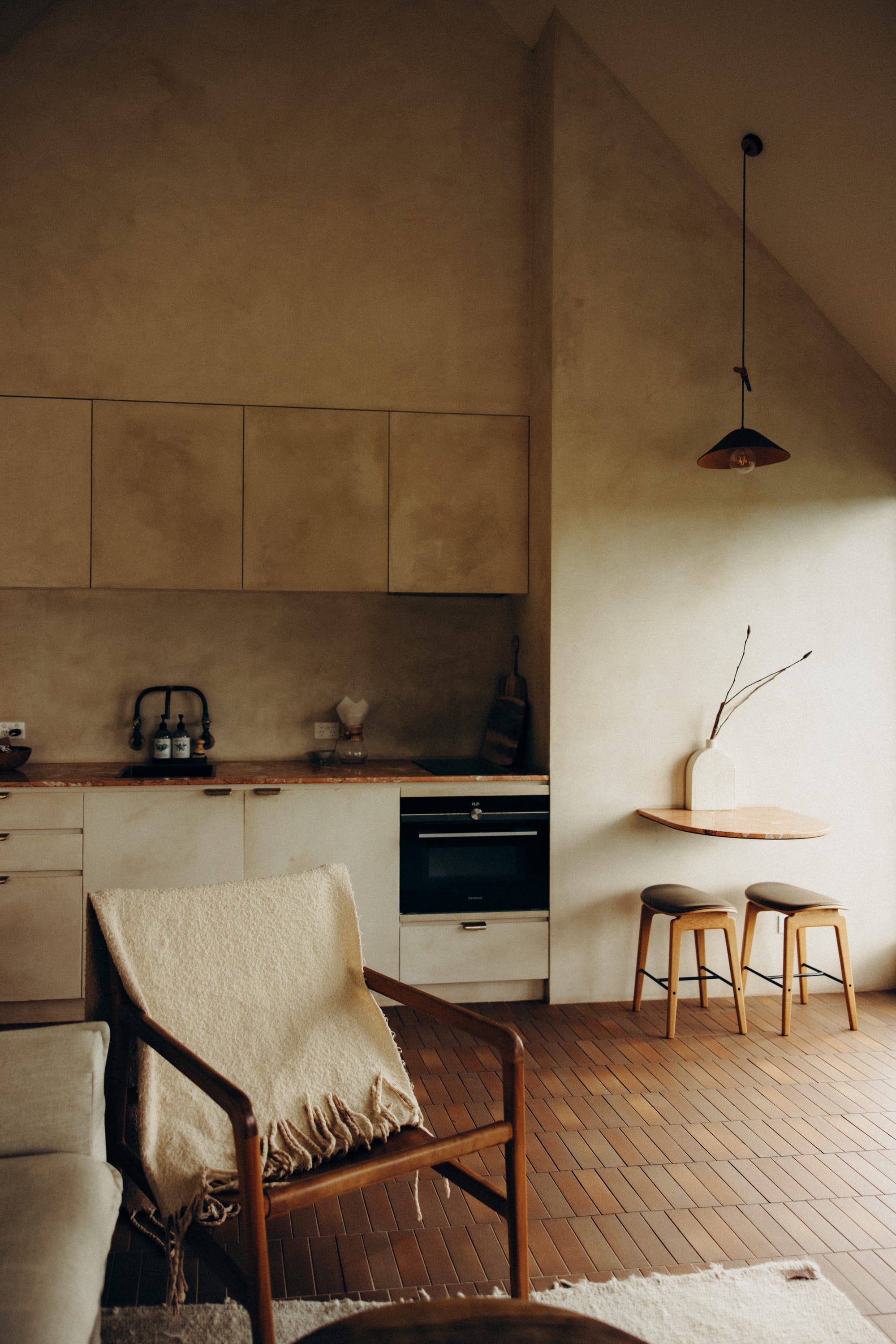 Round Hill Retreat by Round Hill Projects x SI.DE Architecture. Photography by Nicci K. Open plan living, kitchen and dining space with terracotta floor tiles, limewashed walls, timber furnishings and cream, soft decor.