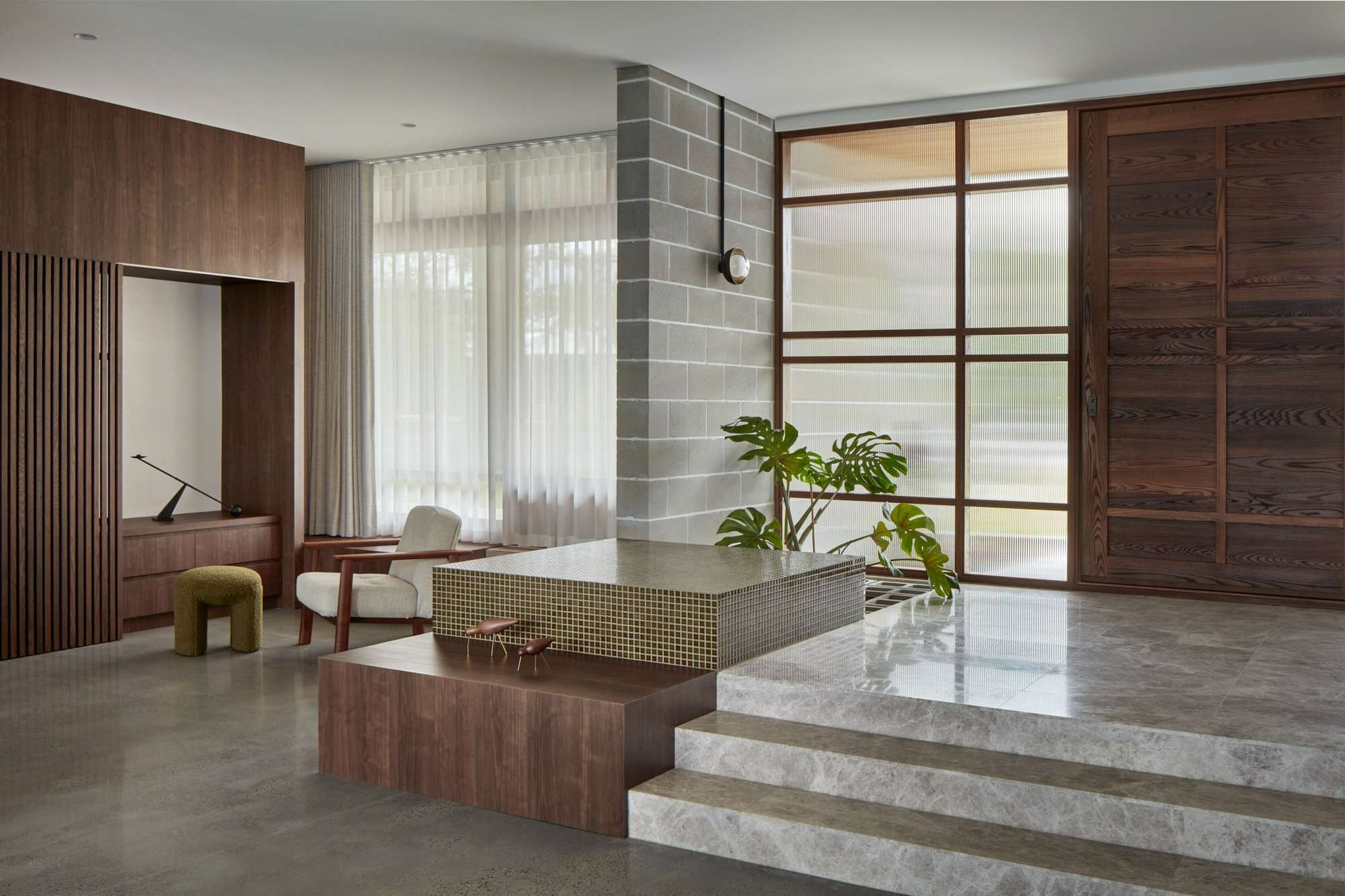 Booth House by State of Kin. Photography by Jack Lovel. Multi-level entrance to residential home with combination of polished concrete floors and marbled grey tiles, green mosaics and deep timber tones. 
