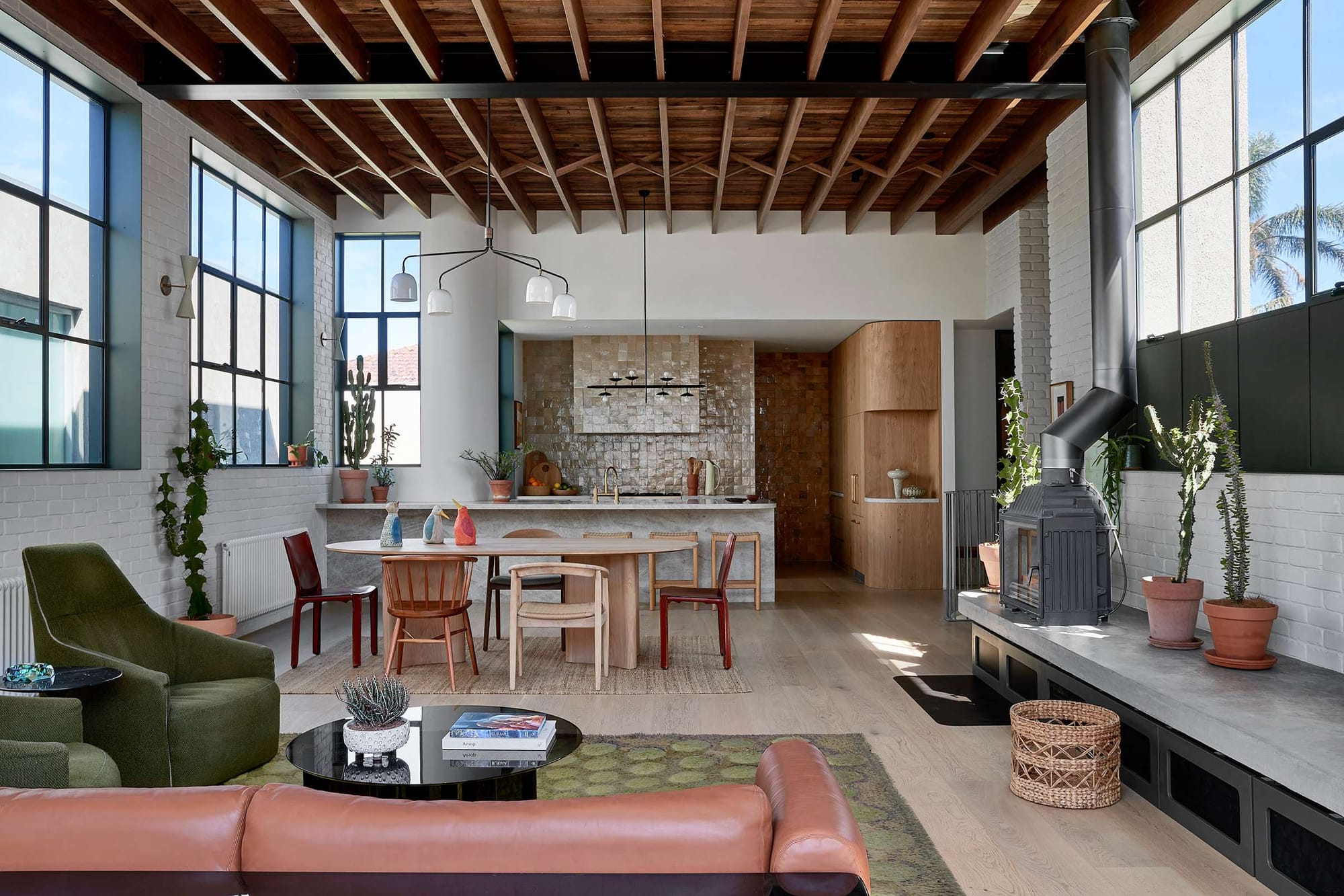 Little Birch by buck&simple. Photography by Tim Pascoe. Front facade of black timber clad home with fluted glass windows and pavers in grass.