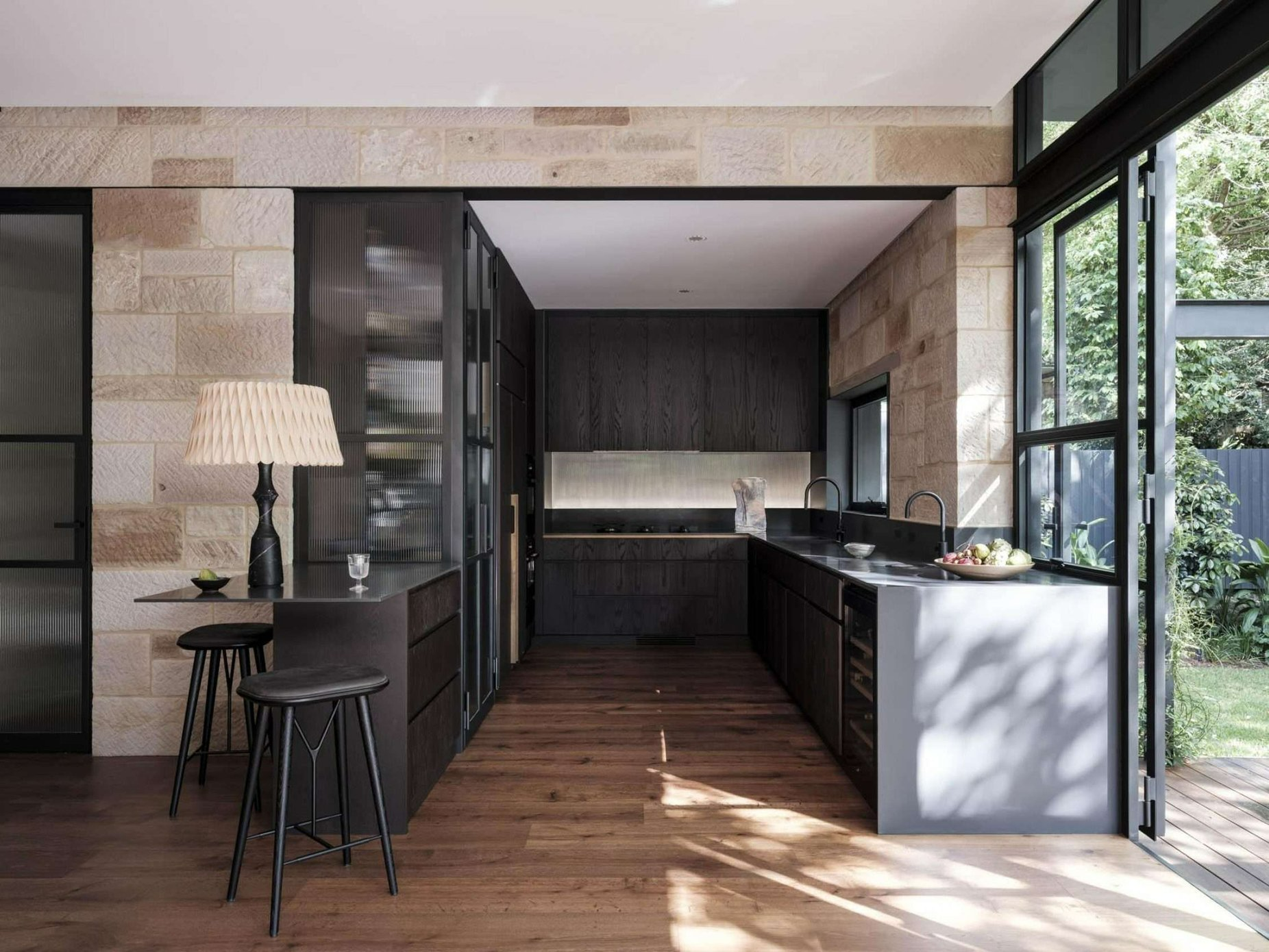Maranatha House by BIJL Architecture. Photography by Tom Ferguson. Kitchen with dark cabinetry and wooden floors in small pocket space.