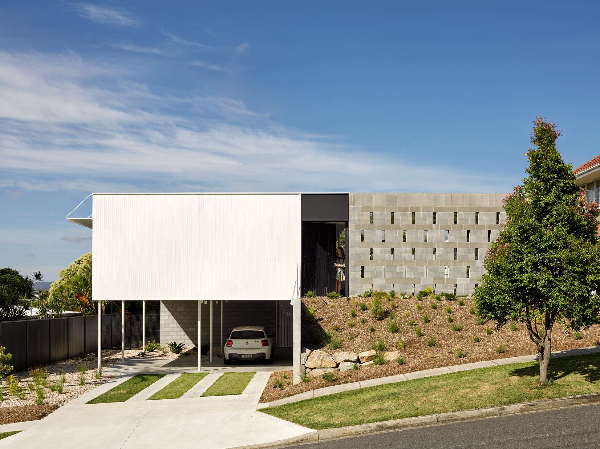 Blok Peregian by Blok Stafford Heights. Photography by Christopher Frederick Jones. Facade of home with large white double height garage, concrete exterior and native garden.