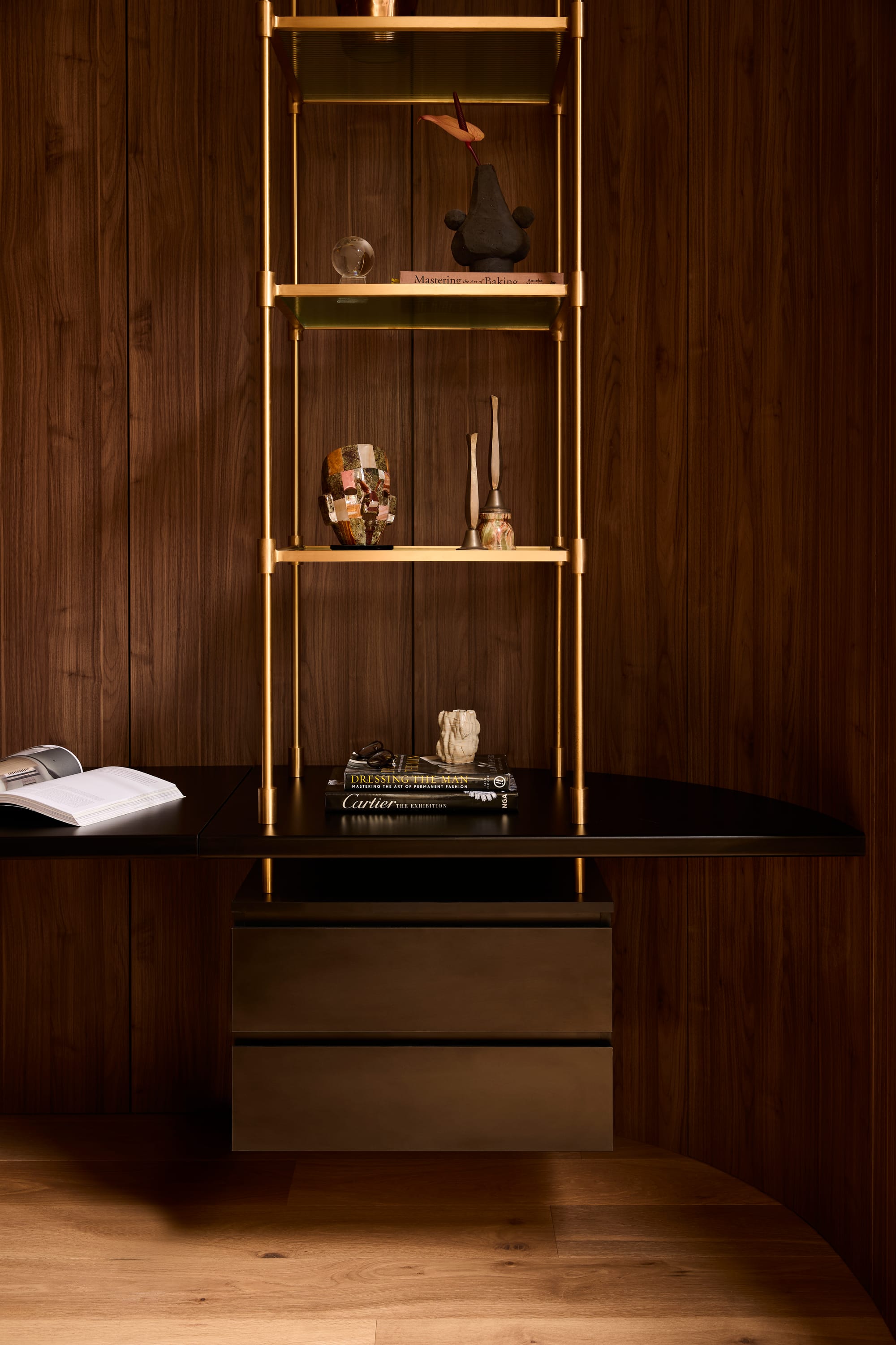 Brixton by Cera Stribley. Photography by Martina Gemmola. Sophisticated home office nook with dark timber walls, brass-framed shelving, black desktop, and curated decorative objects.