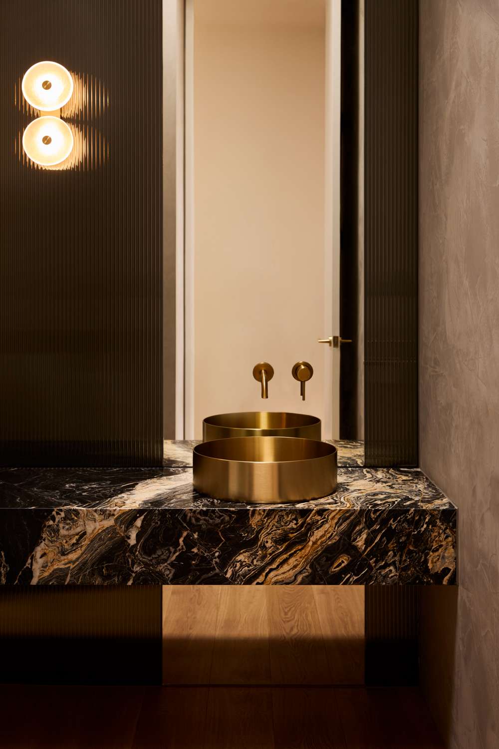 Brixton by Cera Stribley. Photography by Martina Gemmola. Basin top with brass colored sink and tap with full height mirror behind.