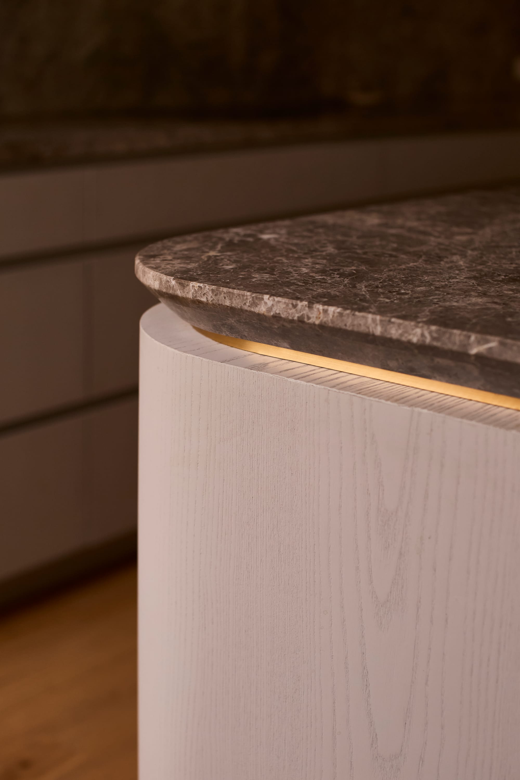Brixton by Cera Stribley. Photography by Martina Gemmola. Close up view of the counter top with grey granite marble edge smoothened with brass lining underneath.
