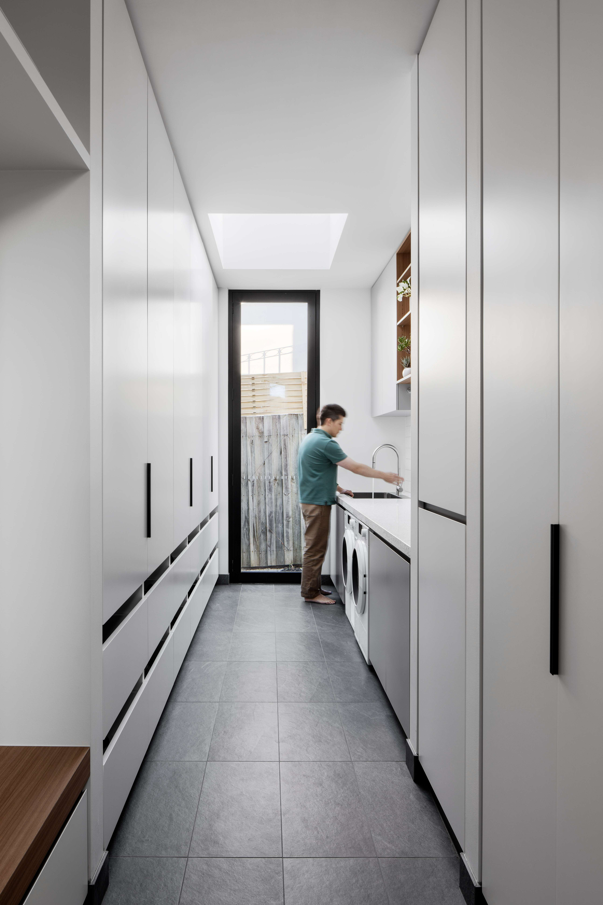 Palm Beach 01 by Watershed Architects. Photography by Tom Ferguson. Laundy with sage green cupboard faces and white finger tiles on splashback.