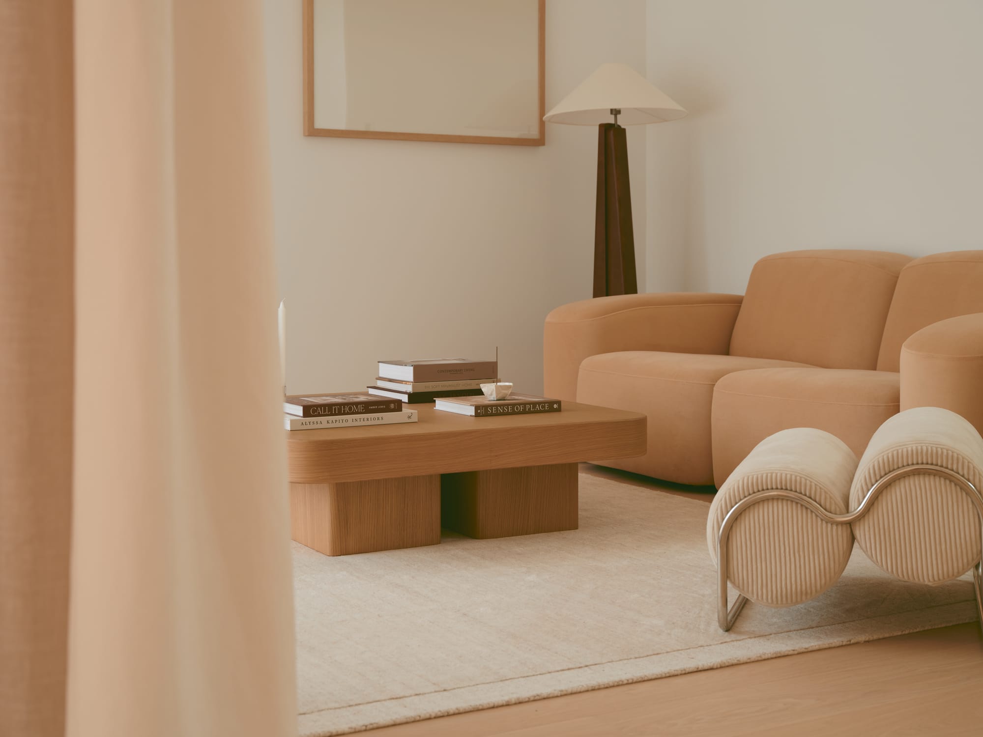 Open-plan living space featuring a sunken velvet lounge, minimalist marble kitchen, timber dining set, and floor-to-ceiling glass doors that connect to an outdoor area.