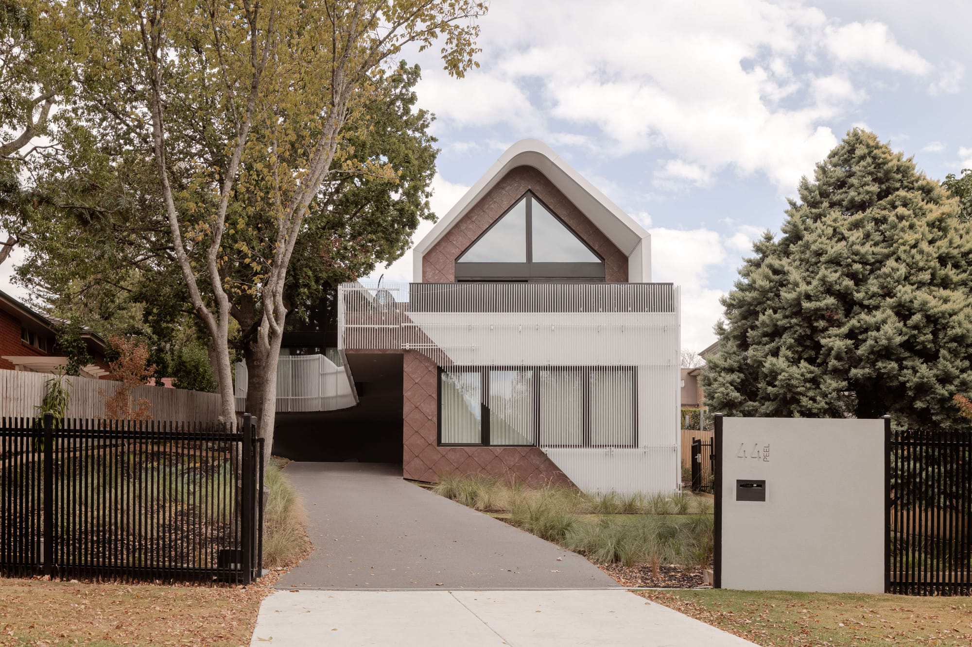 TREE HOUSE by R Architecture. Photography by CM Photography. Hallway with built-in wooden cabinet leading to backyard.