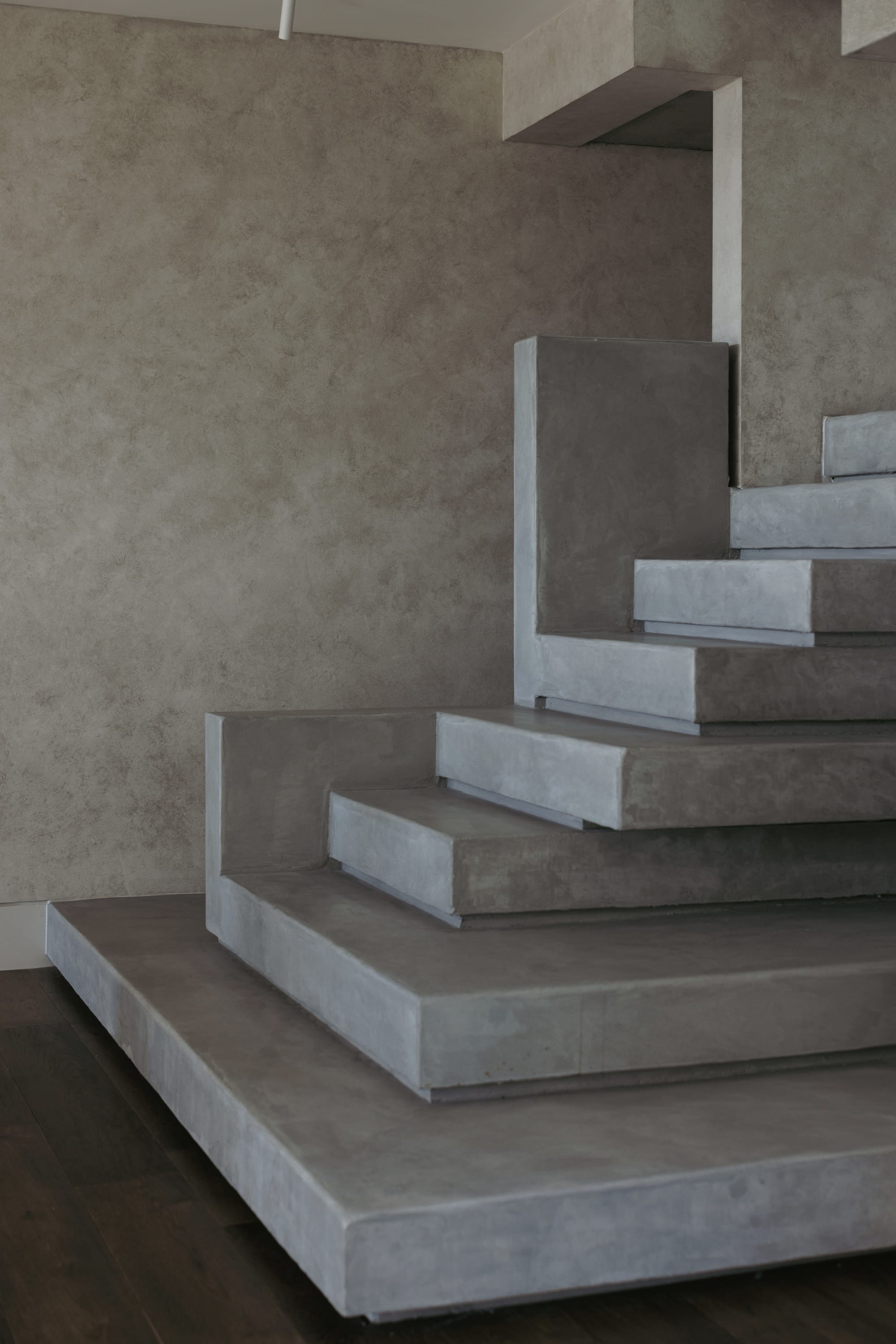 Little Birch by buck&simple. Photography by Tim Pascoe. Concrete tiered staircase in space with dark timber flooring and limewashed walls.