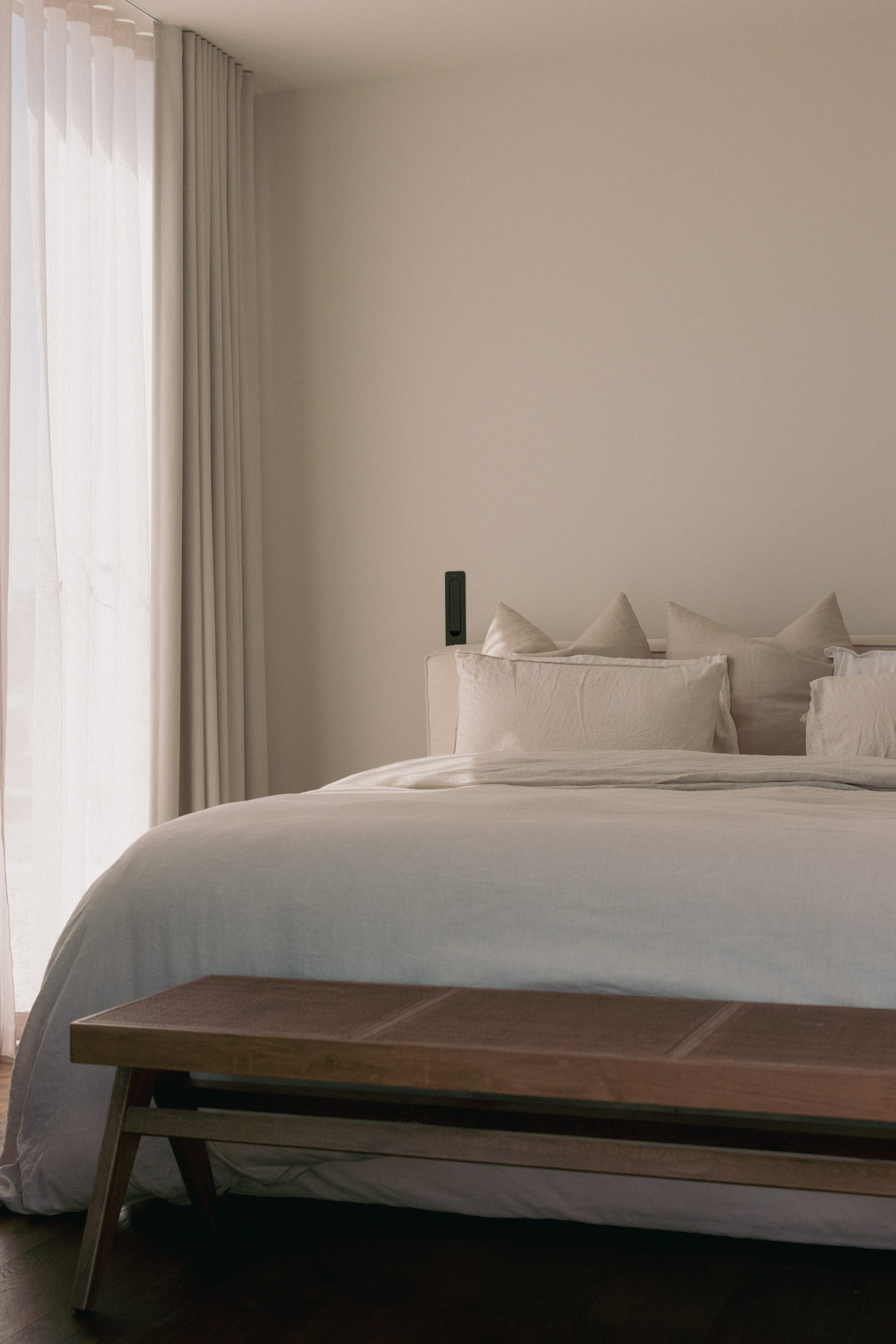 Little Birch by buck&simple. Photography by Tim Pascoe. Bedroom with white bedding, timber bench at end of bed, white walls and white sheer curtains. 