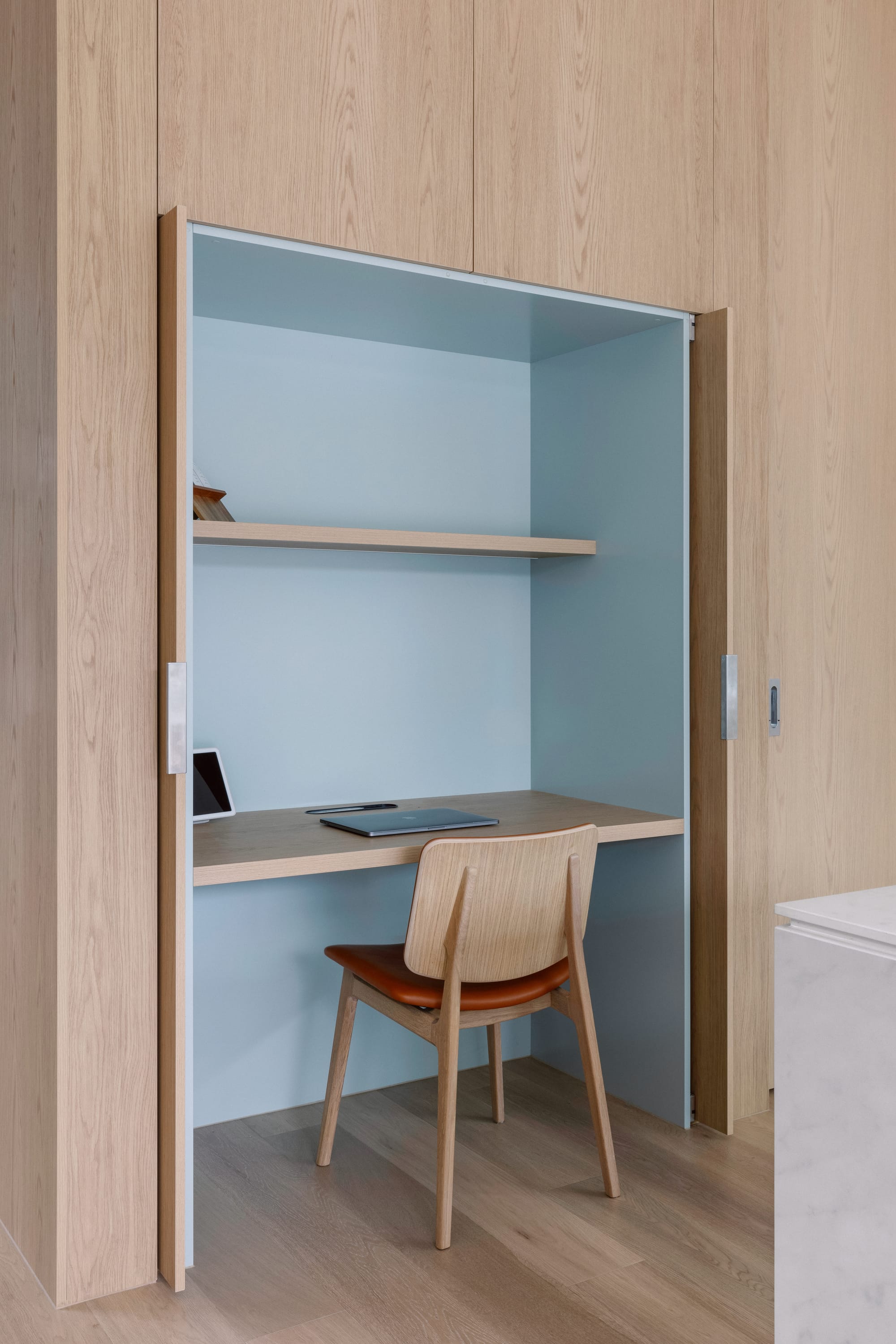 Auburn Residence by Chan Architecture. Photography by Elise Scott. Study nook with blue walls, timber floating desk and shelf, enveloped in timber cabinetry and with timber chair. 
