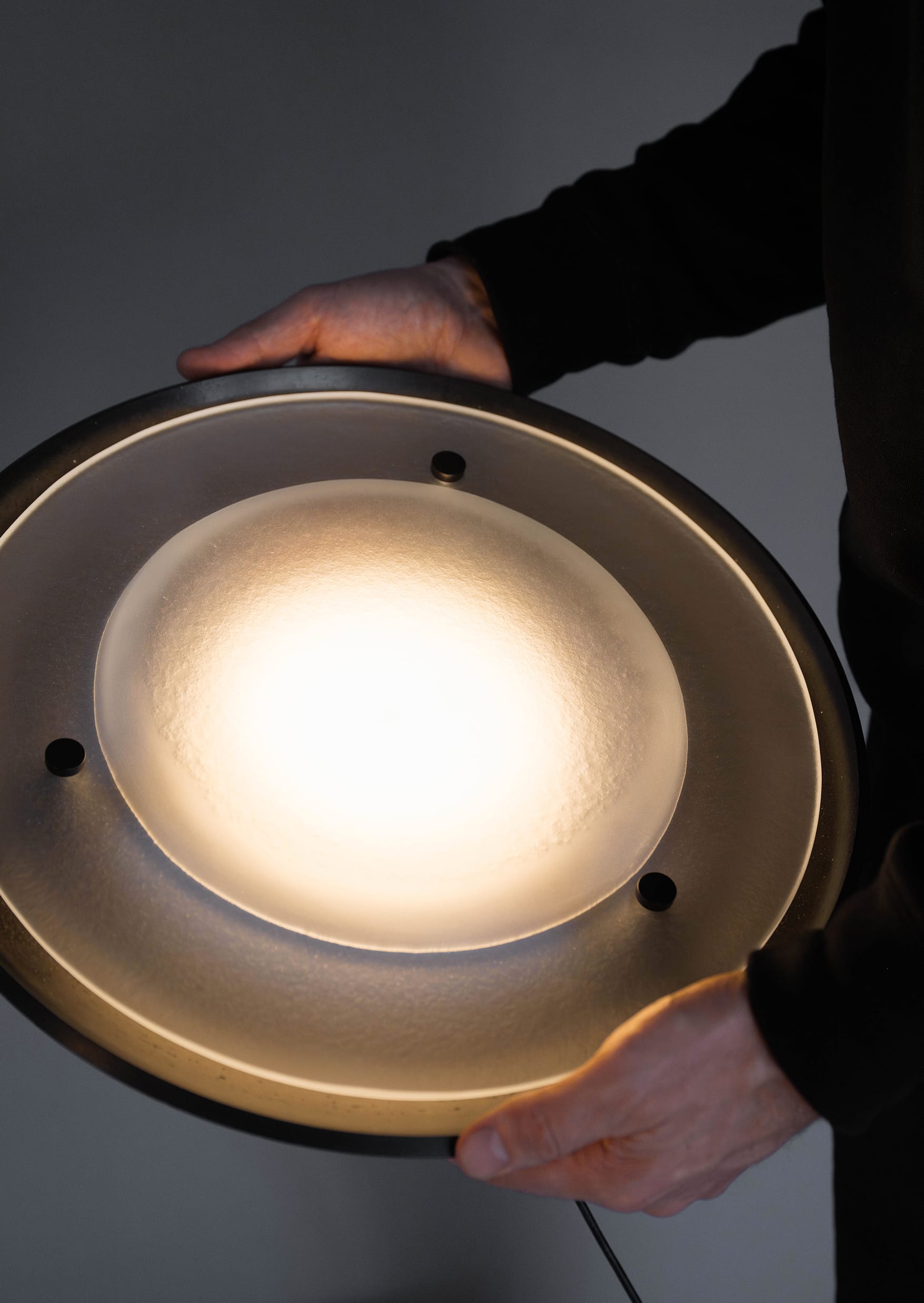 Husk Collection By South Drawn. Photography by Reannon Smith. A detail of the Husk light reveals the soft, textured Zeoform diffuser glowing gently in hand.