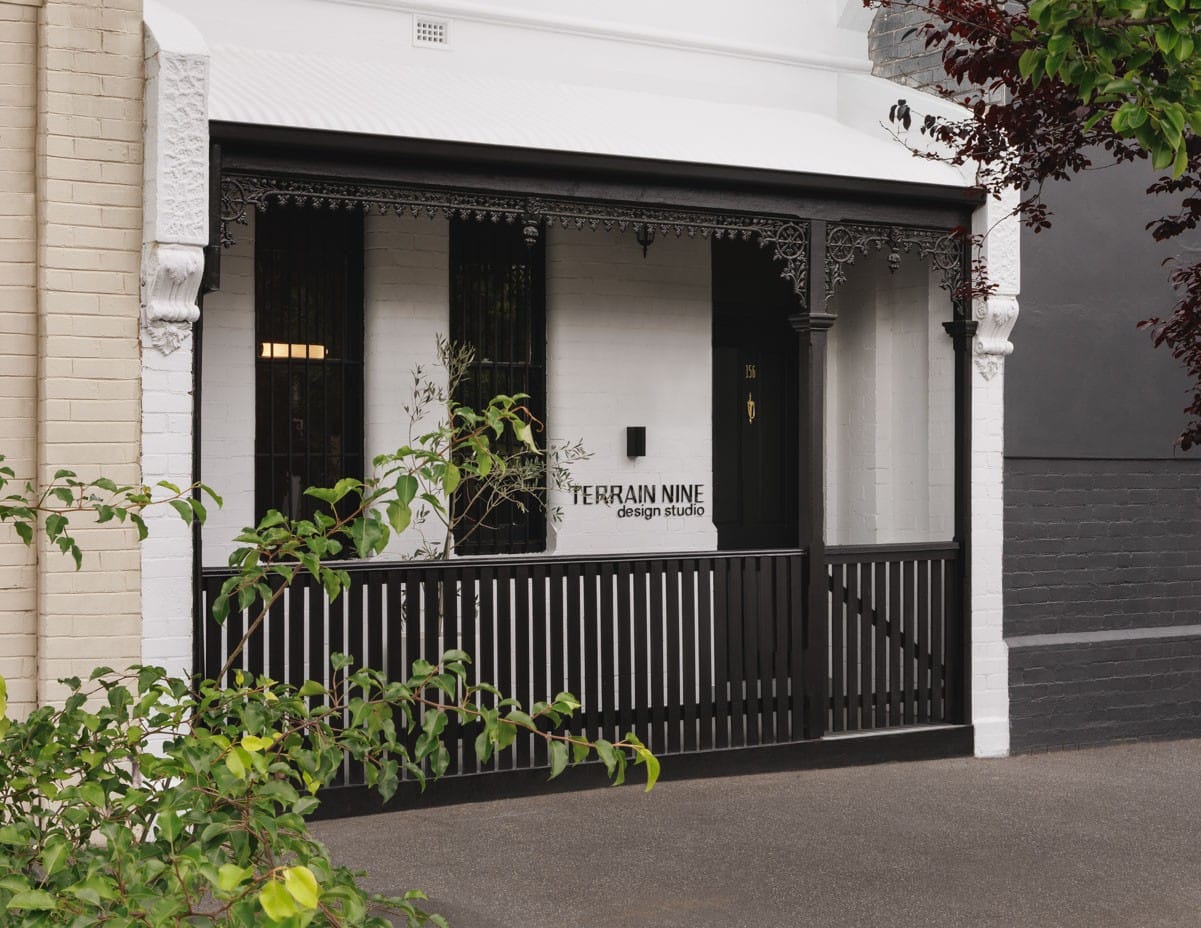 House of Terrain 9 by Terrain Nine Design Studio. Photography by Timothy Kaye. Facade of Terrain Nine Design Studio featuring a monochrome Victorian terrace with ornate iron lacework, black picket railing, and contrasting white brick walls.