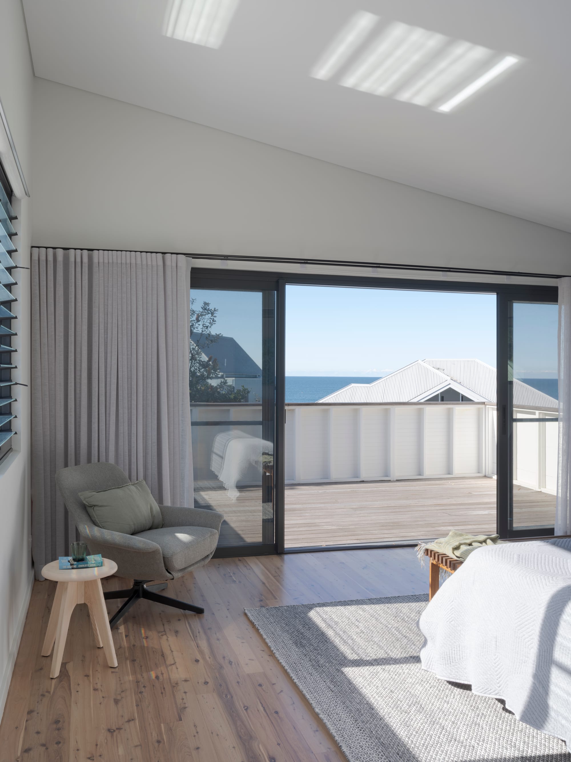 Three Points House by BIJL Architecture. Photography by Tom Ferguson.Light-filled bedroom with timber floors, ocean views, and sliding glass doors opening to a private deck.