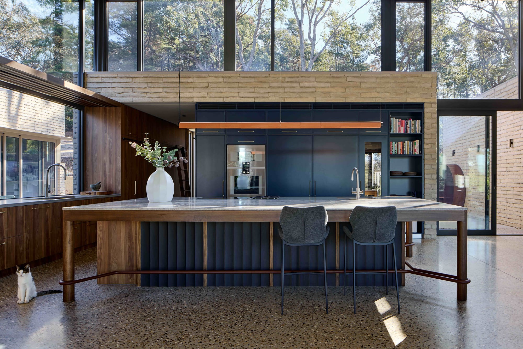 Korinda House by BENT Architecture. Photography by Tatjana Plitt. Kitchen with concrete countertop, navy blue cabinetry and timbercrete walls. 